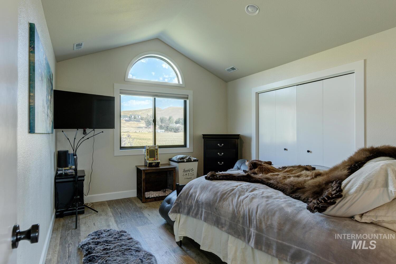 Bedroom featuring vaulted ceiling, LVP floors, and a closet