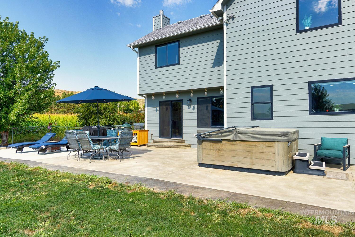 Back of house featuring a hot tub and patio area
