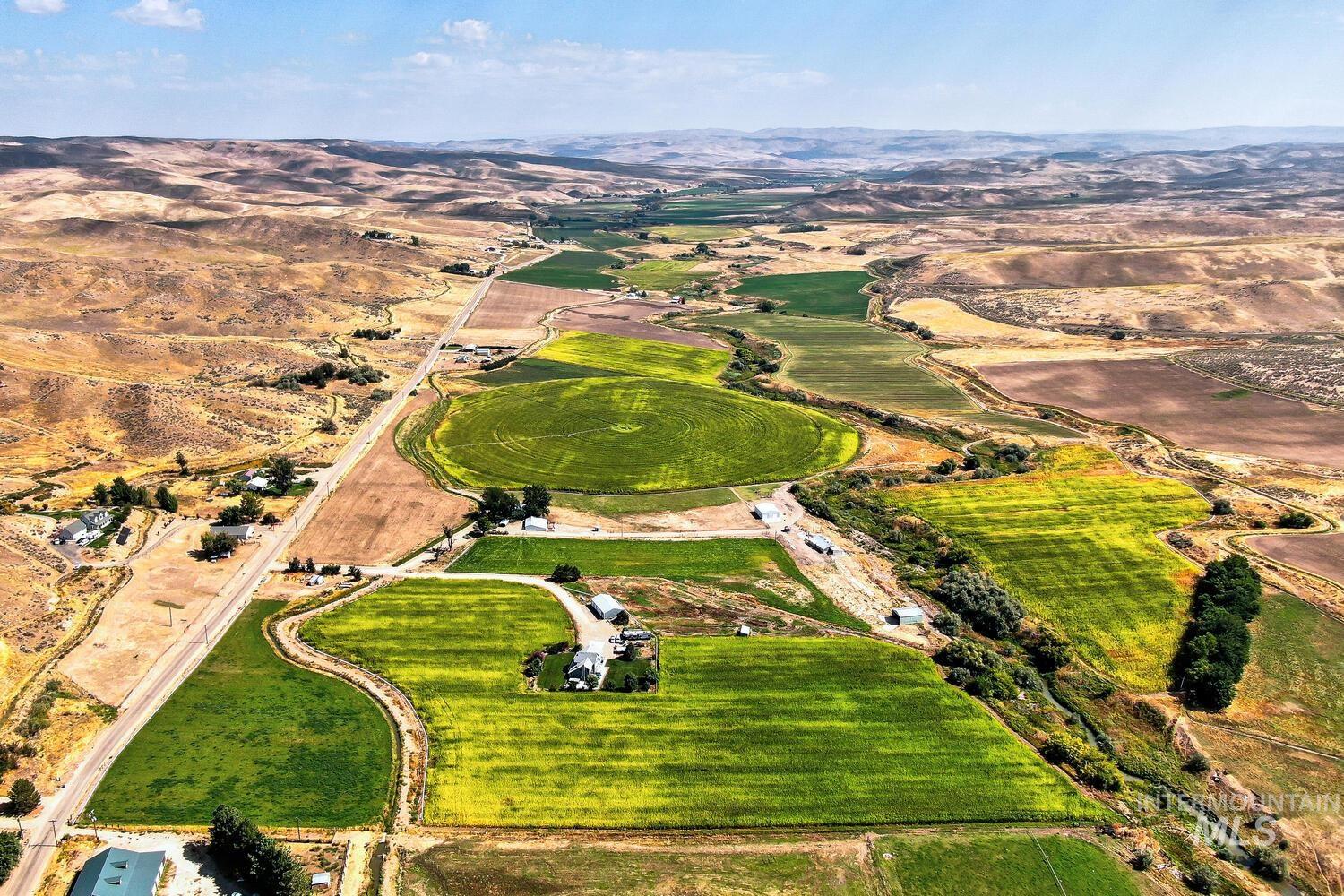 Aerial overview of property's location with rural landscape and a mountainous background