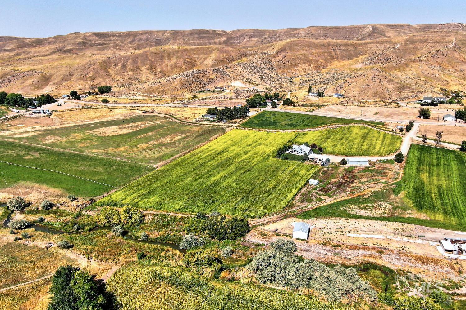 Aerial view of property's location with rural landscape and a mountain backdrop