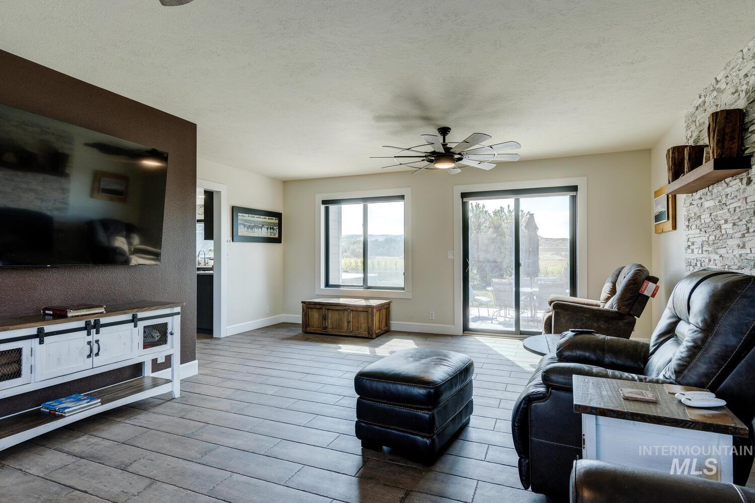 Living room featuring tiled floors, and ceiling fans