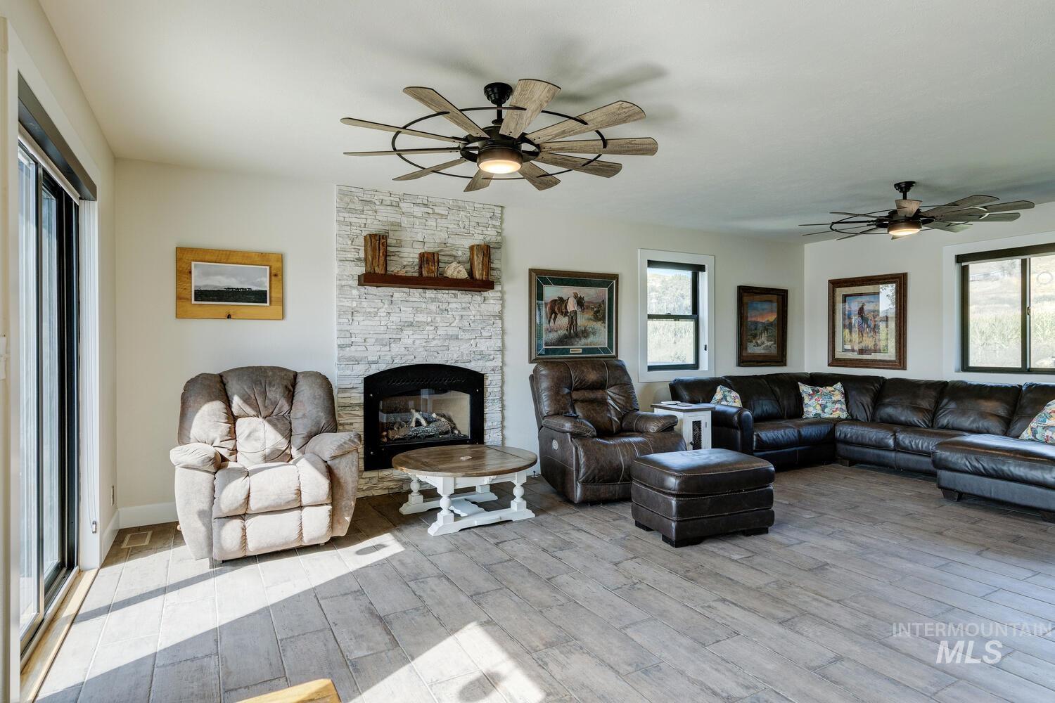 Living room featuring ceiling fans, tiled floors, and a fireplace