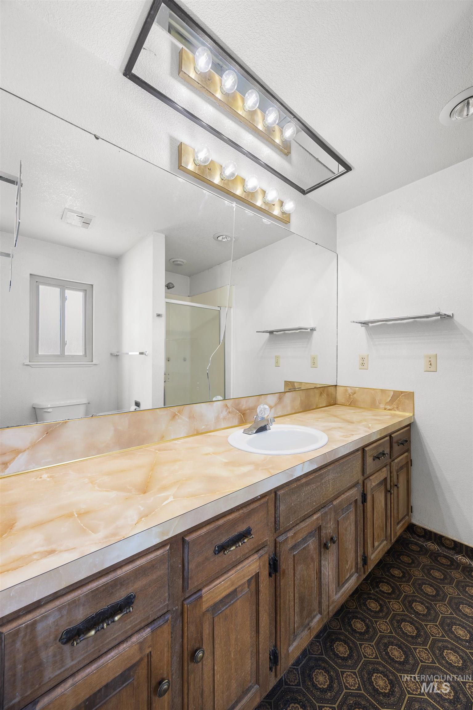 Bathroom with a stall shower, vanity, and a textured ceiling