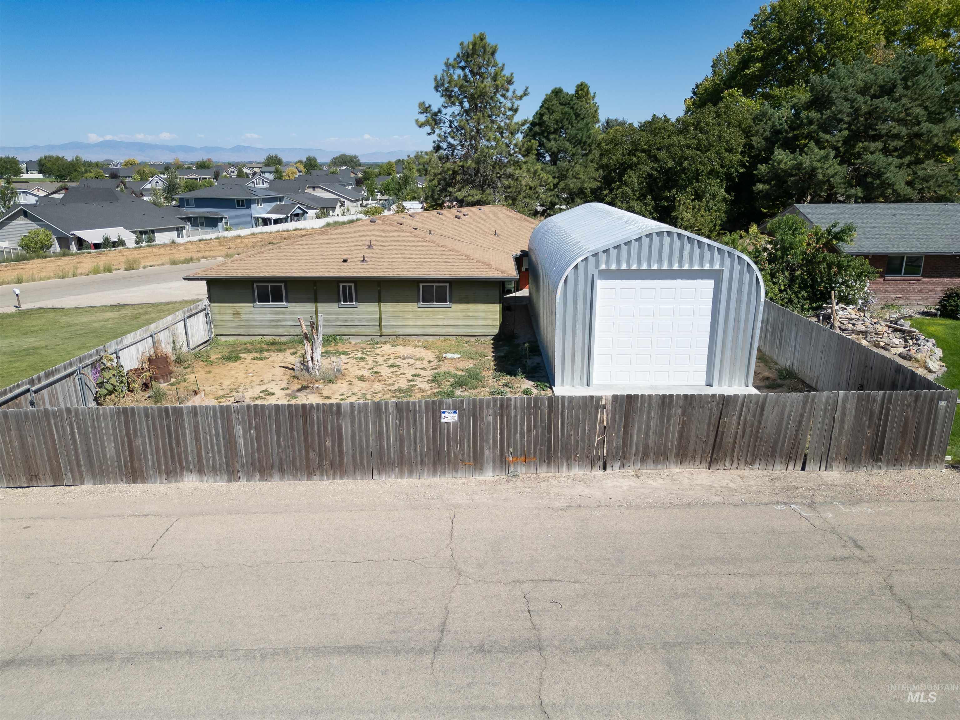Fenced yard with a residential view, an outdoor structure, and a garage