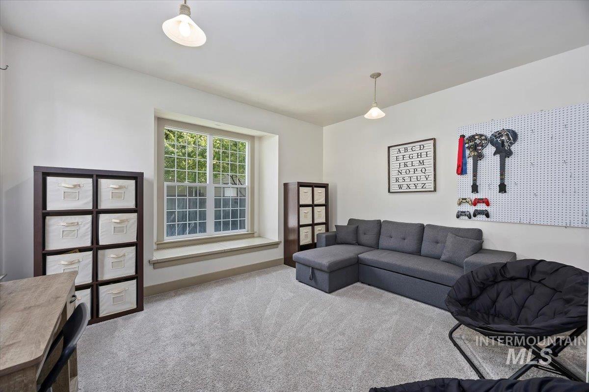 Living area featuring carpet flooring and baseboards