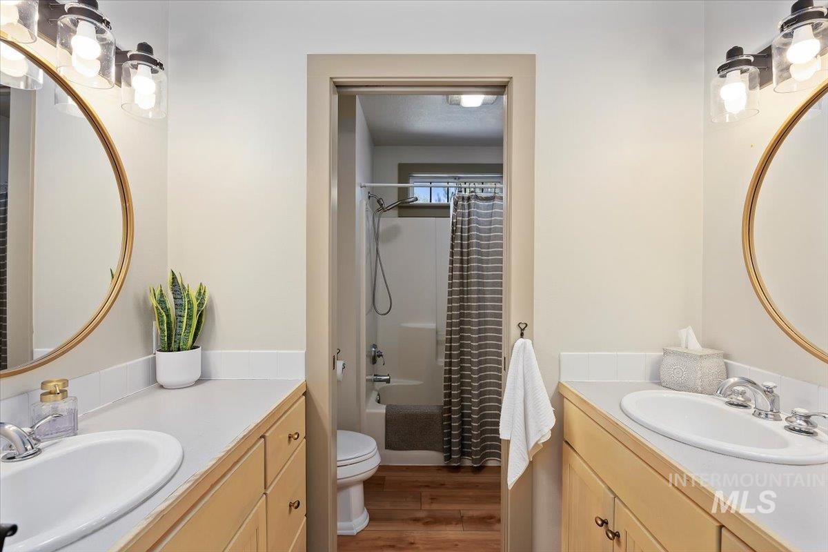 Bathroom with dark wood-style flooring, shower / tub combo, and vanity