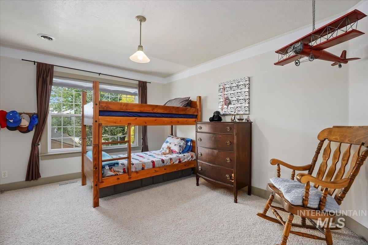 Carpeted bedroom featuring baseboards and a textured ceiling