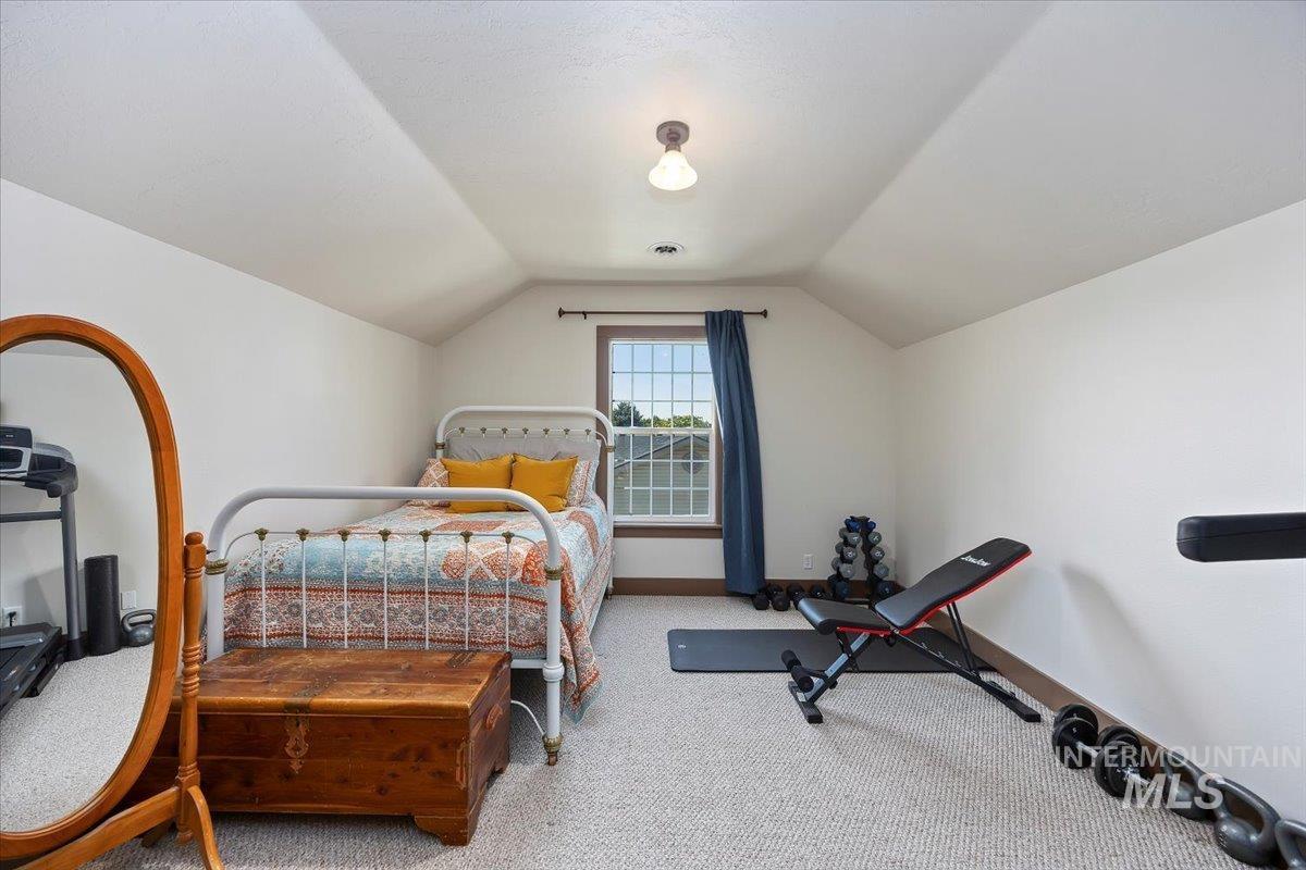Bedroom with carpet and vaulted ceiling