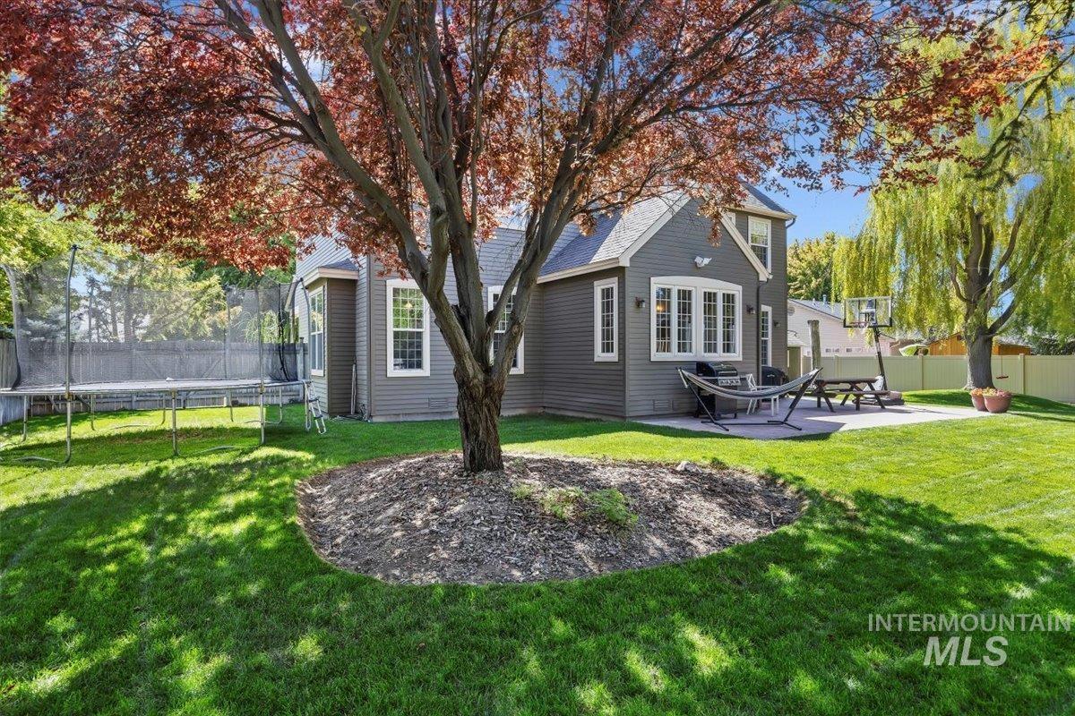 Back of property featuring a trampoline and a patio