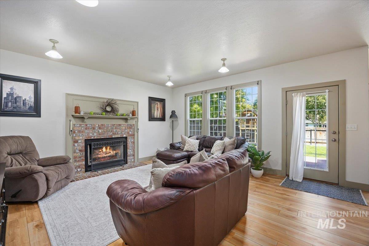 Living room featuring plenty of natural light, light wood-type flooring, and a fireplace