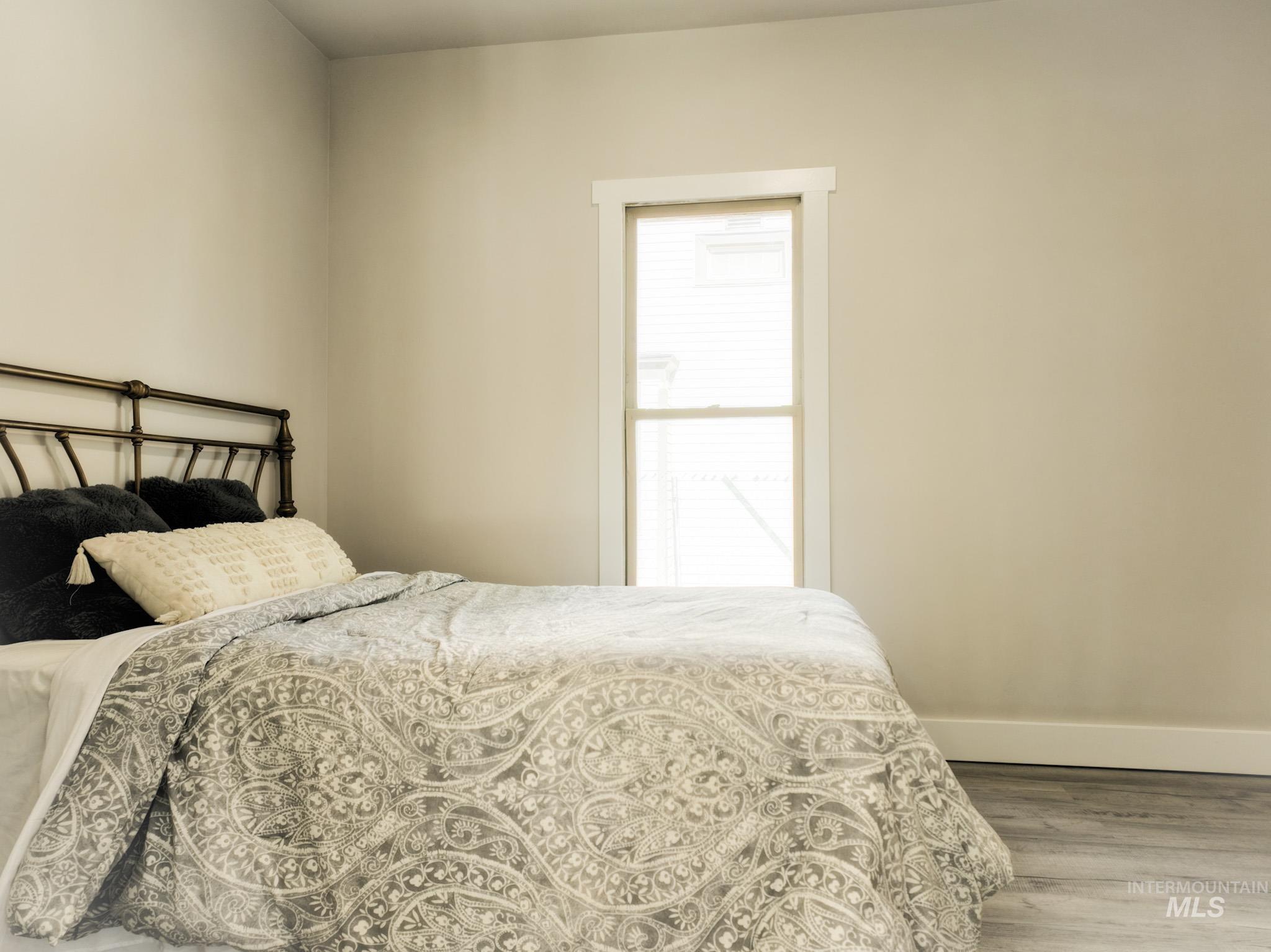 Bedroom featuring wood finished floors and baseboards
