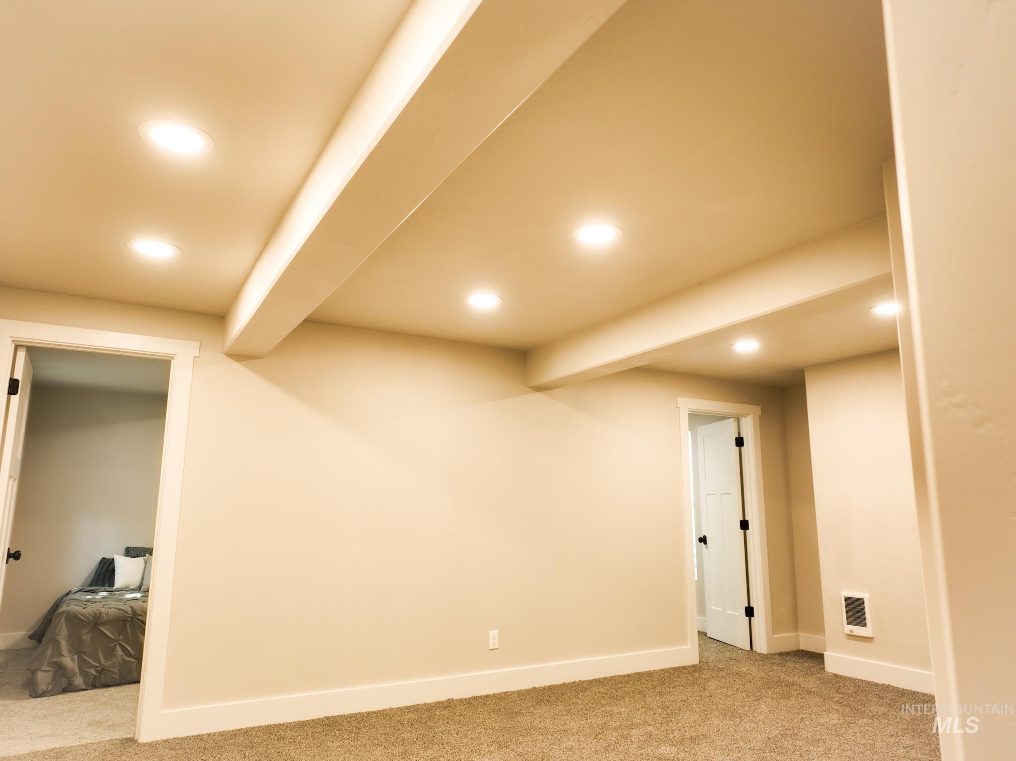 Finished below grade area with recessed lighting, light carpet, and heating unit