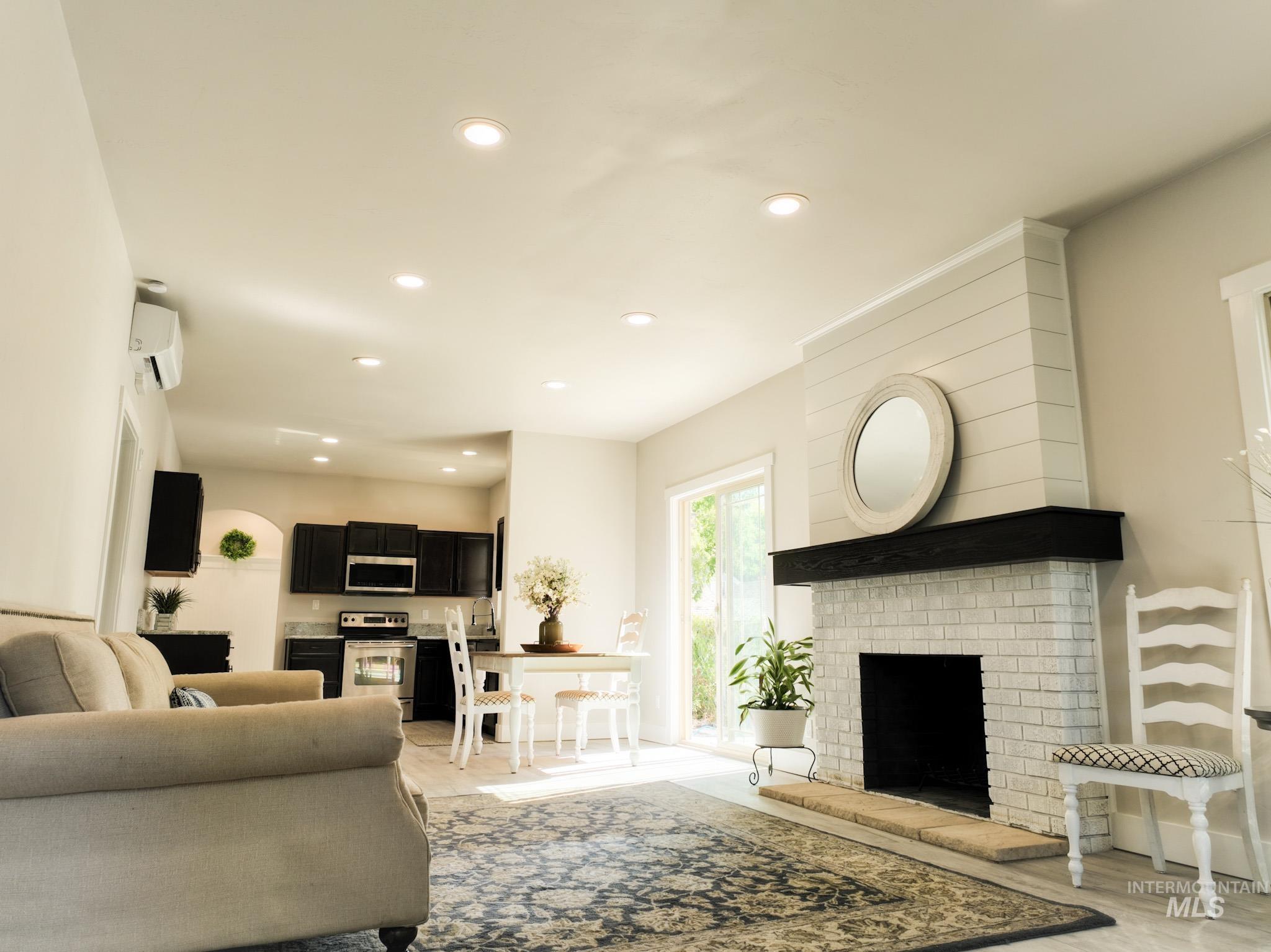 Living room with recessed lighting, light wood-style flooring, a fireplace, and a wall mounted AC