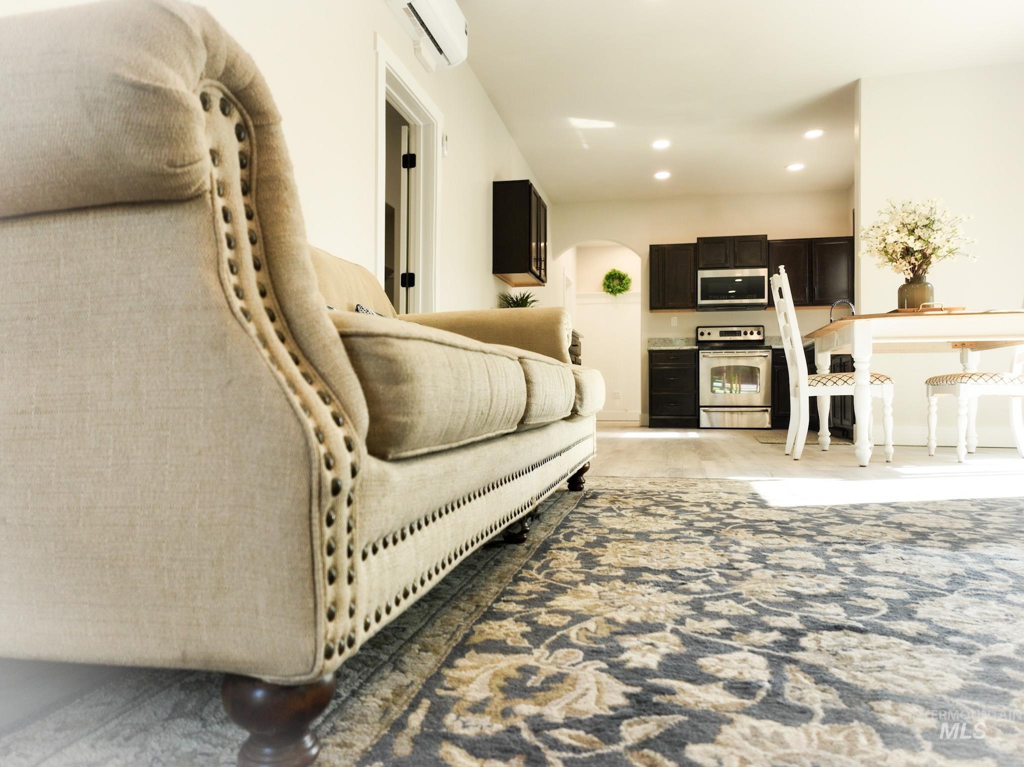Living area featuring a wall unit AC and recessed lighting