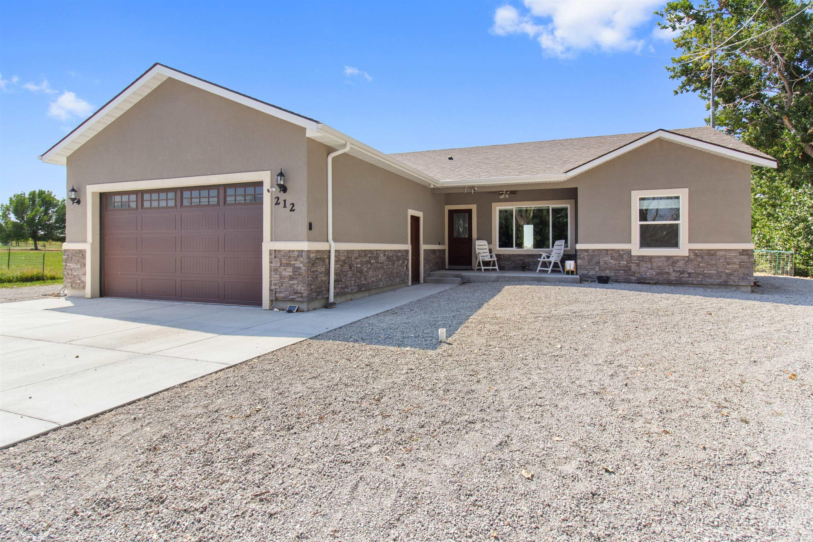 Single story home featuring stone siding, stucco siding, driveway, and a garage