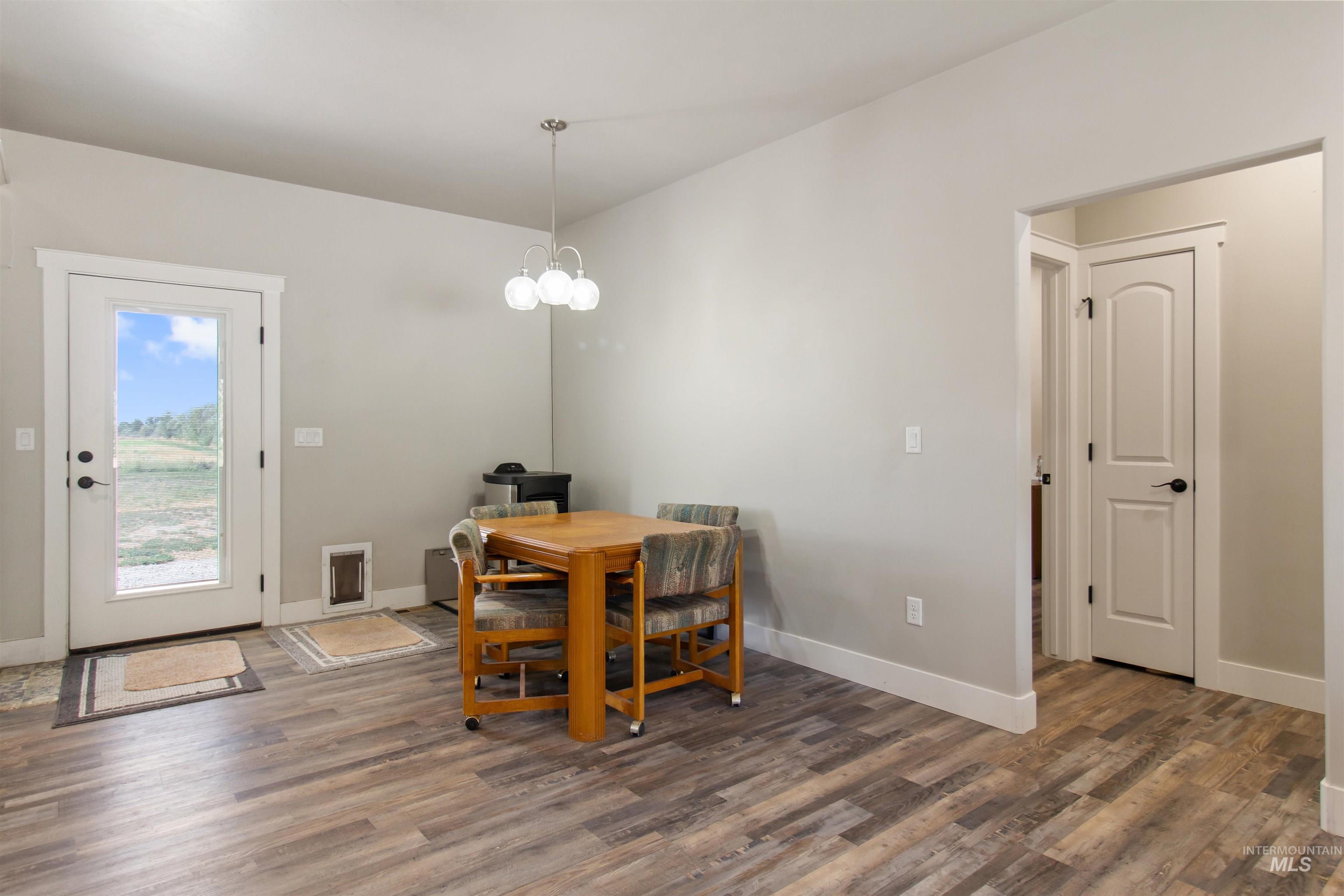 Dining room with dark wood-style floors and a chandelier