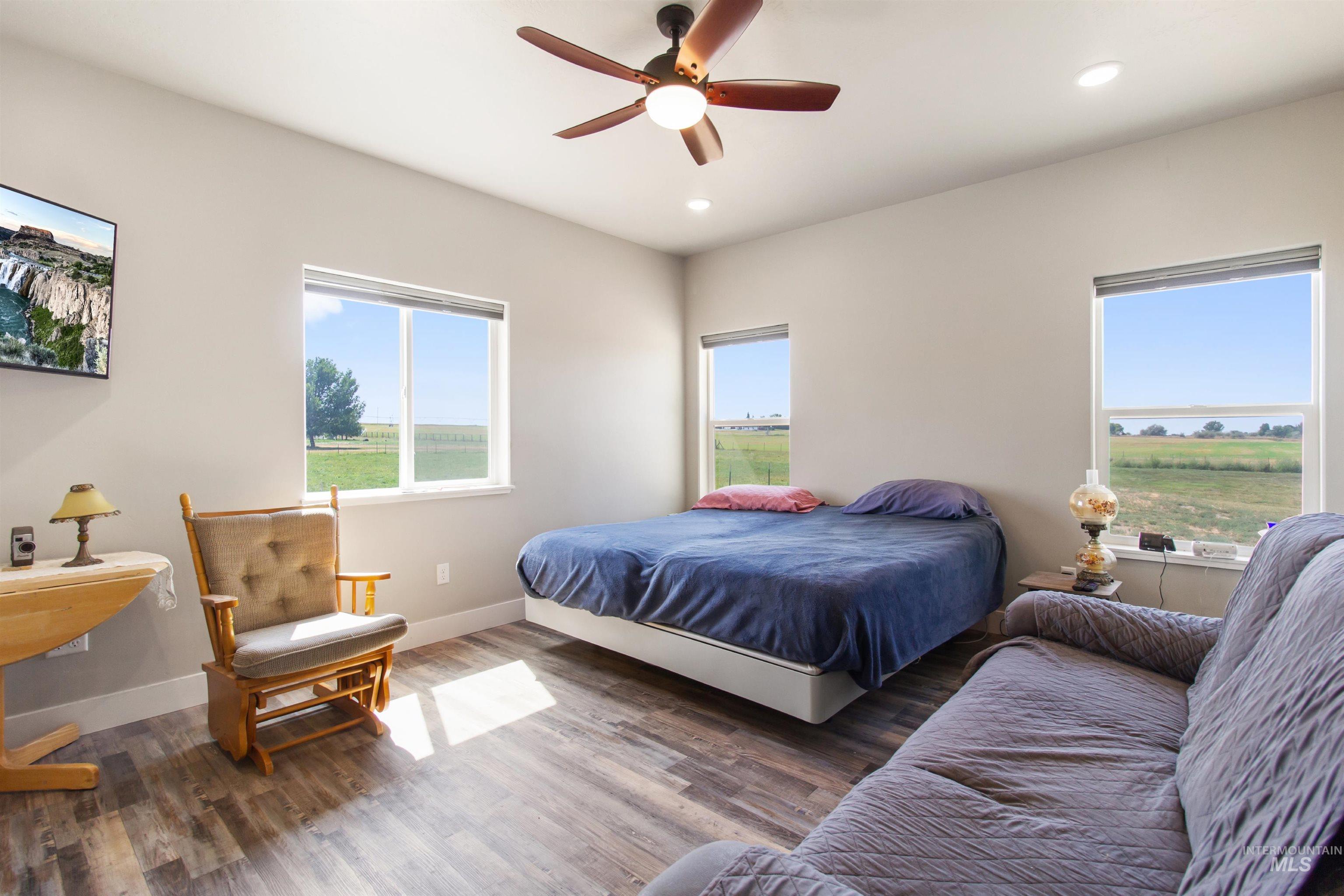 Bedroom with wood finished floors, recessed lighting, and a ceiling fan