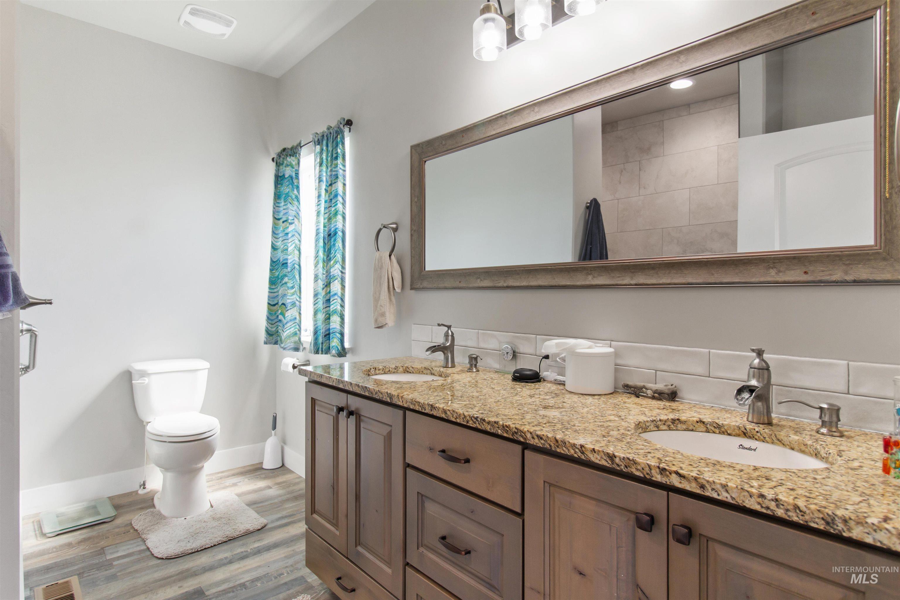 Bathroom featuring light wood-type flooring and double vanity