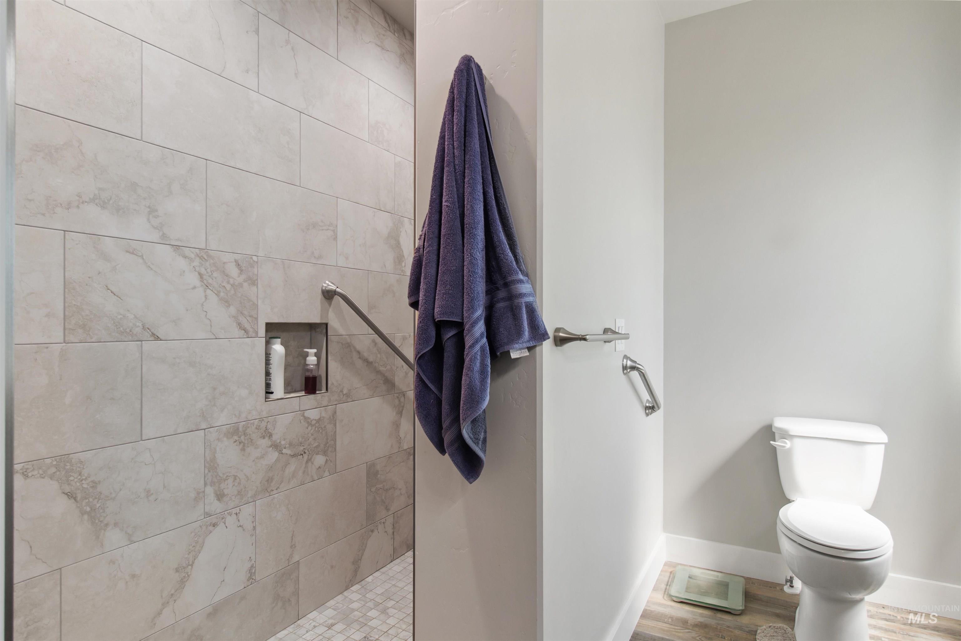 Full bathroom with a walk in shower and wood finished floors