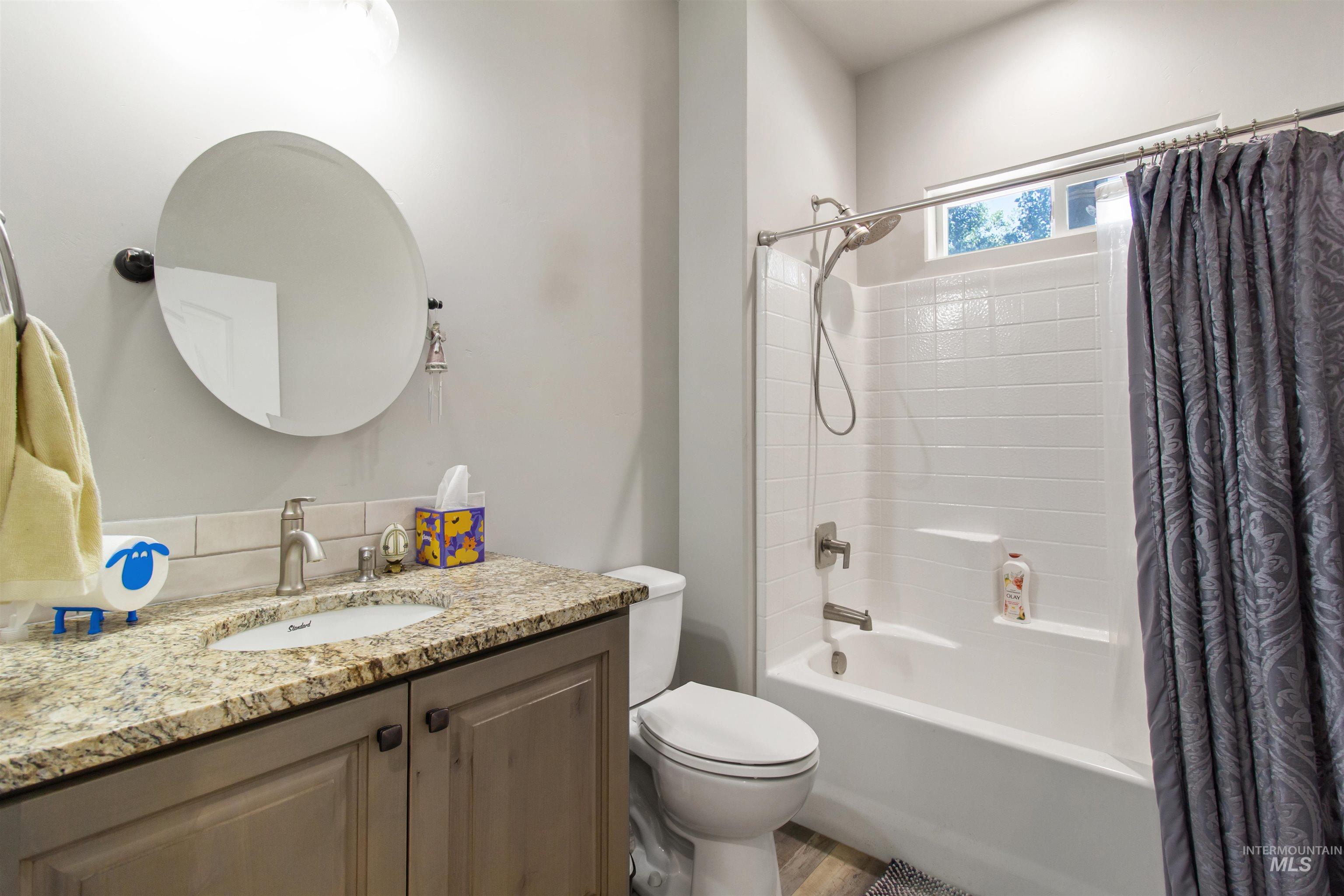 Bathroom with shower / bath combination with curtain and vanity