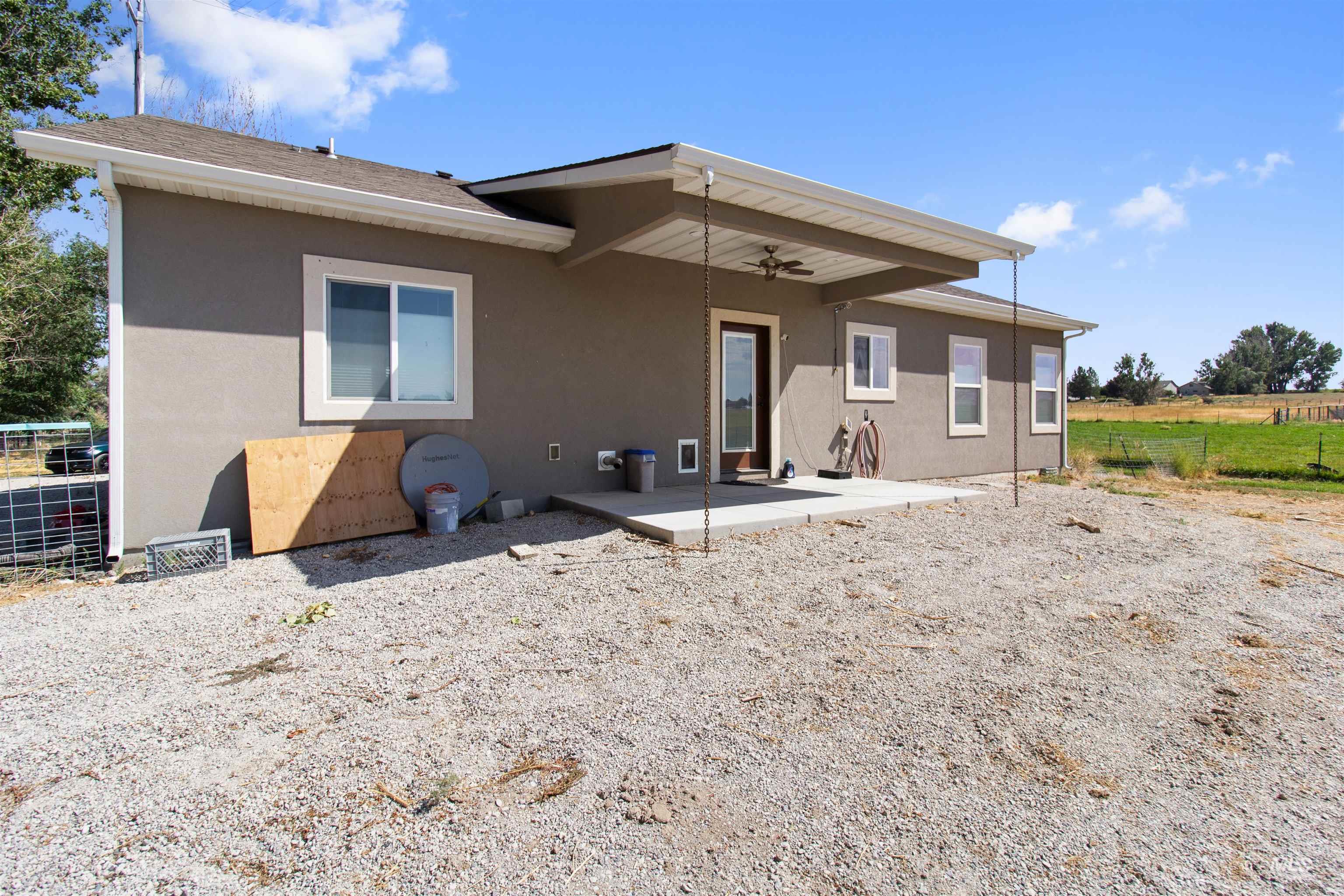 Rear view of house featuring a patio area, stucco siding, and ceiling fan