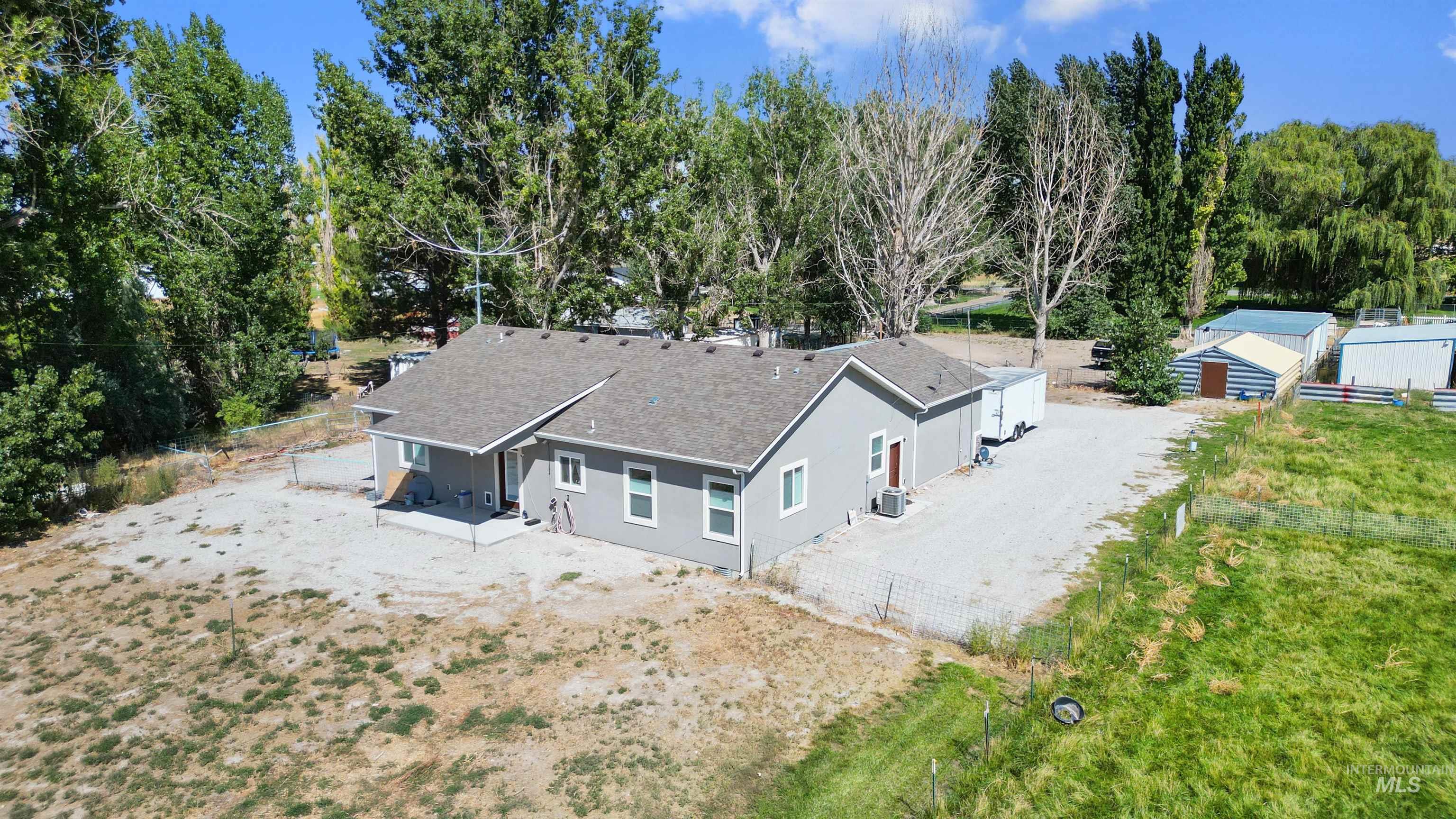 Aerial view of property and surrounding area with a tree filled landscape