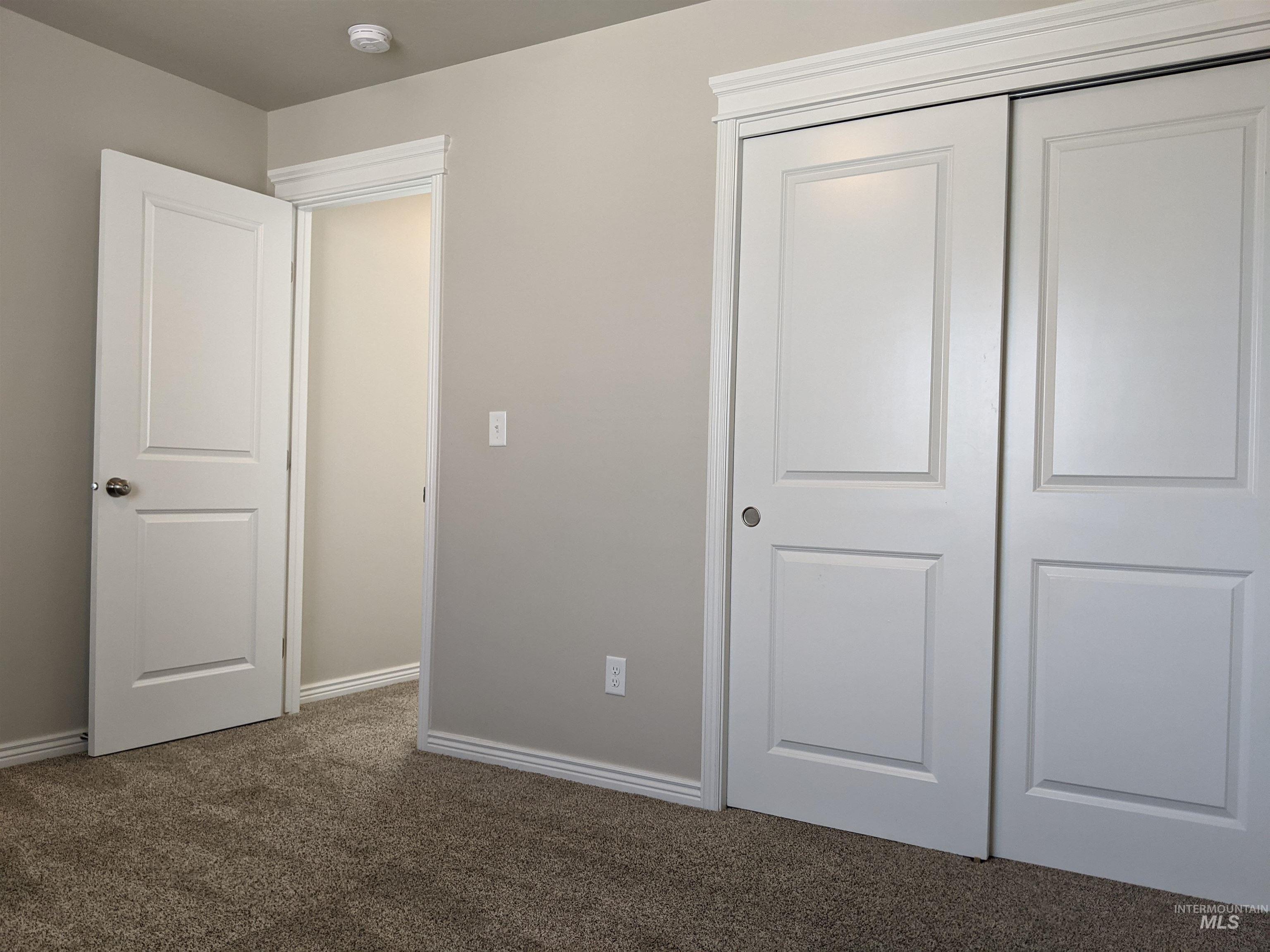 Unfurnished bedroom featuring dark colored carpet and a closet