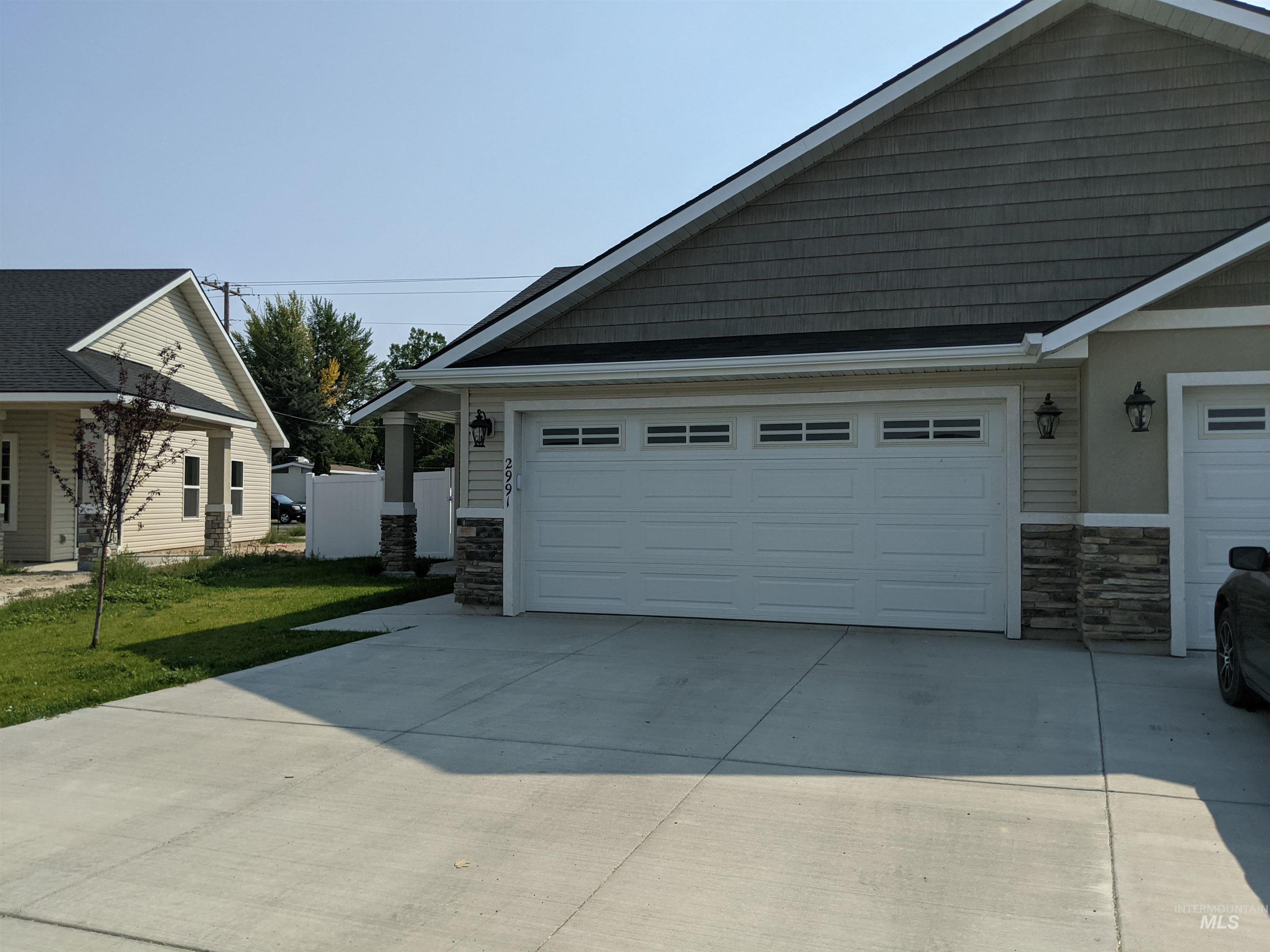 View of property exterior featuring stone siding and driveway