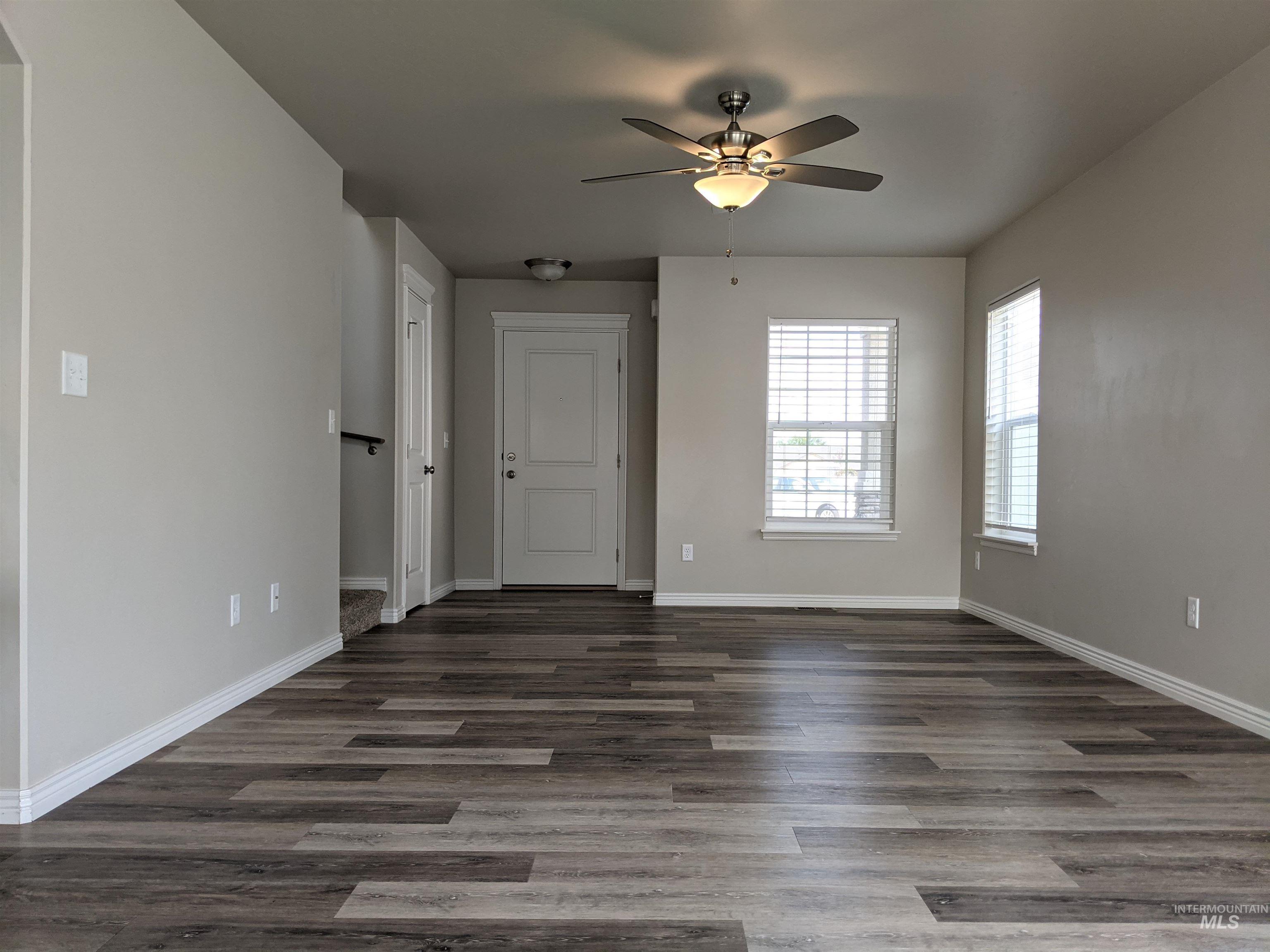 Empty room featuring dark wood-style floors and ceiling fan