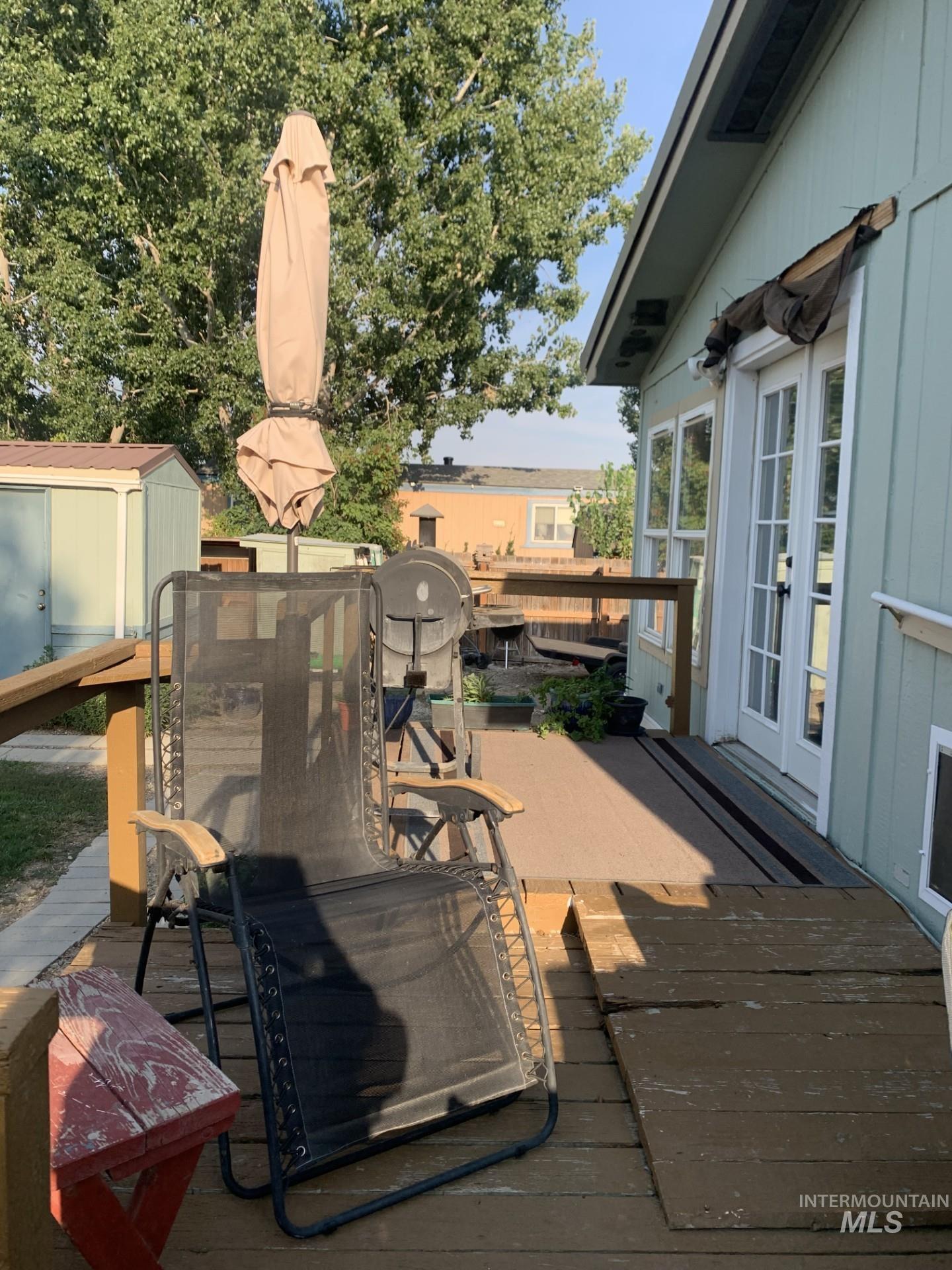Deck with a storage shed, outdoor dining space, and french doors
