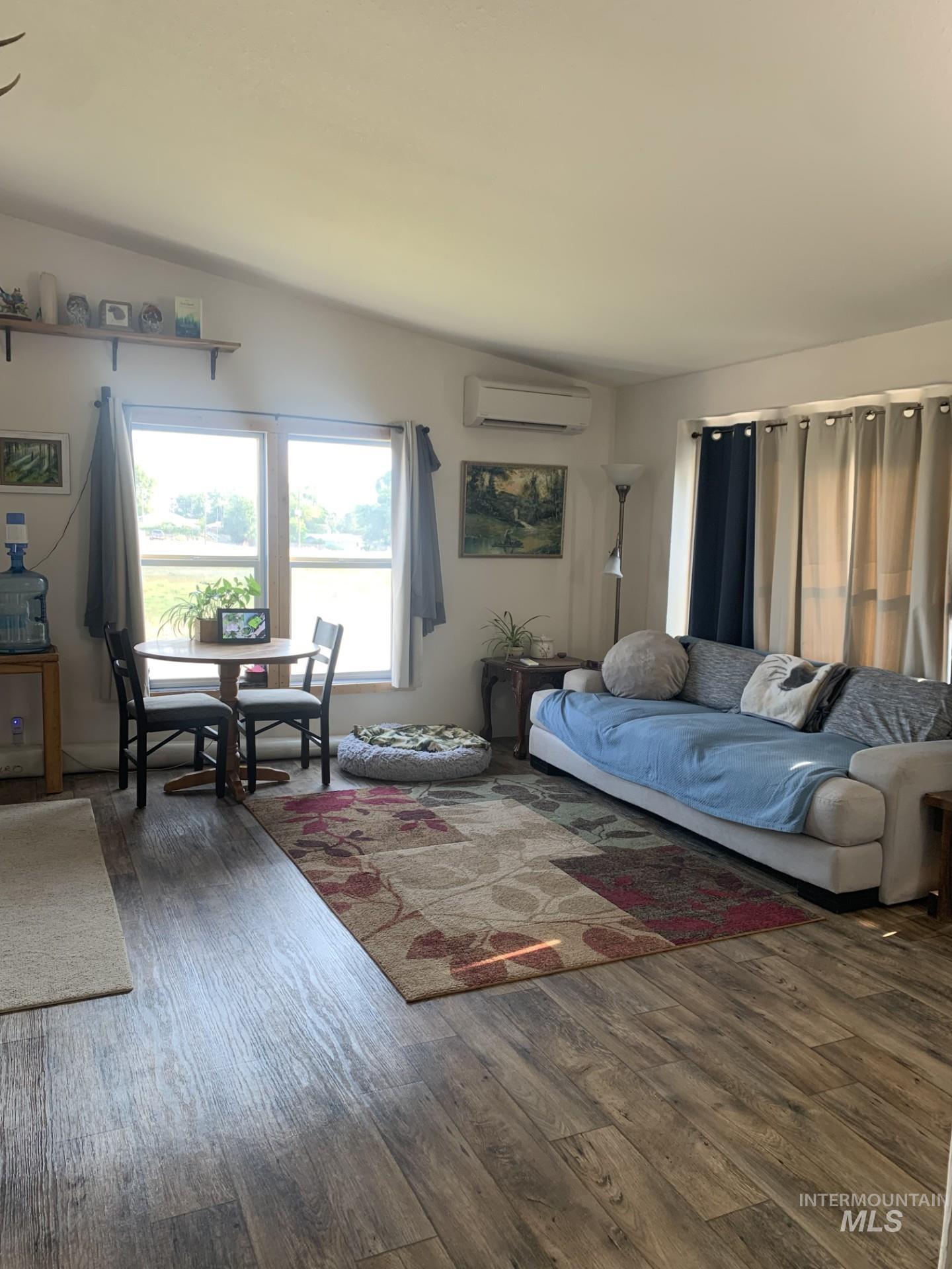 Living room featuring dark wood finished floors and a wall mounted AC