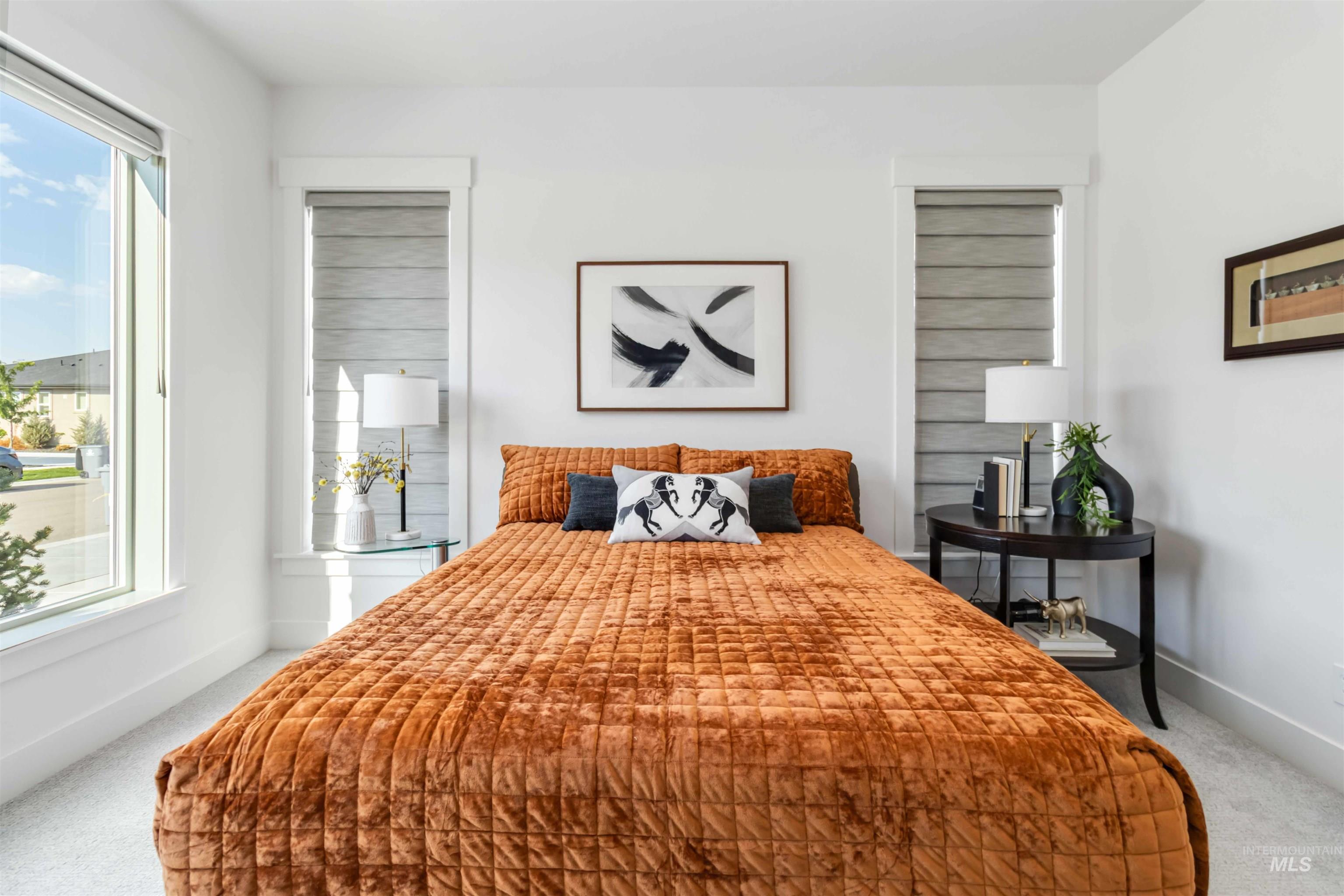 Bedroom with light colored carpet and baseboards