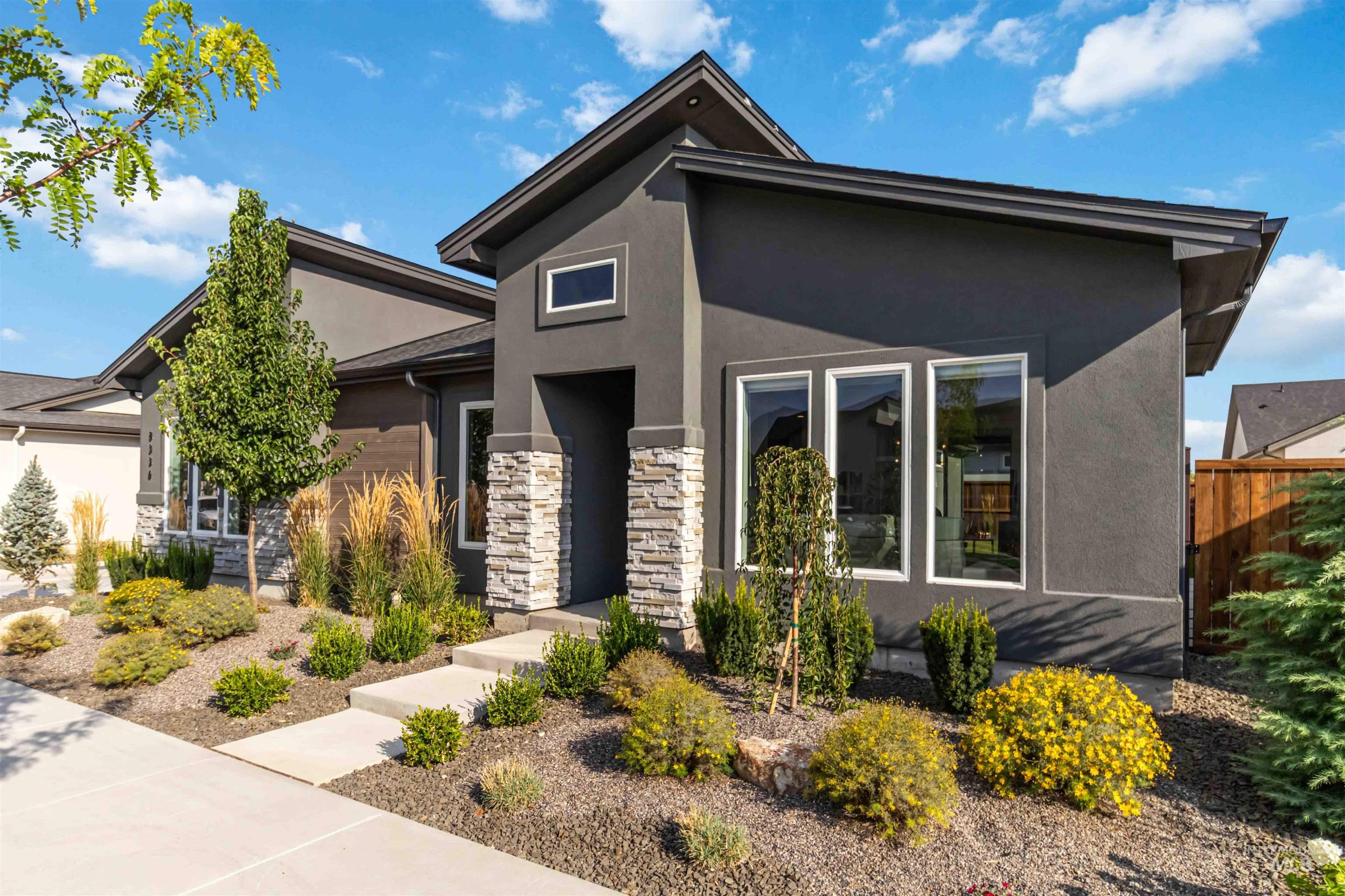 View of front of house featuring stucco siding and stone siding