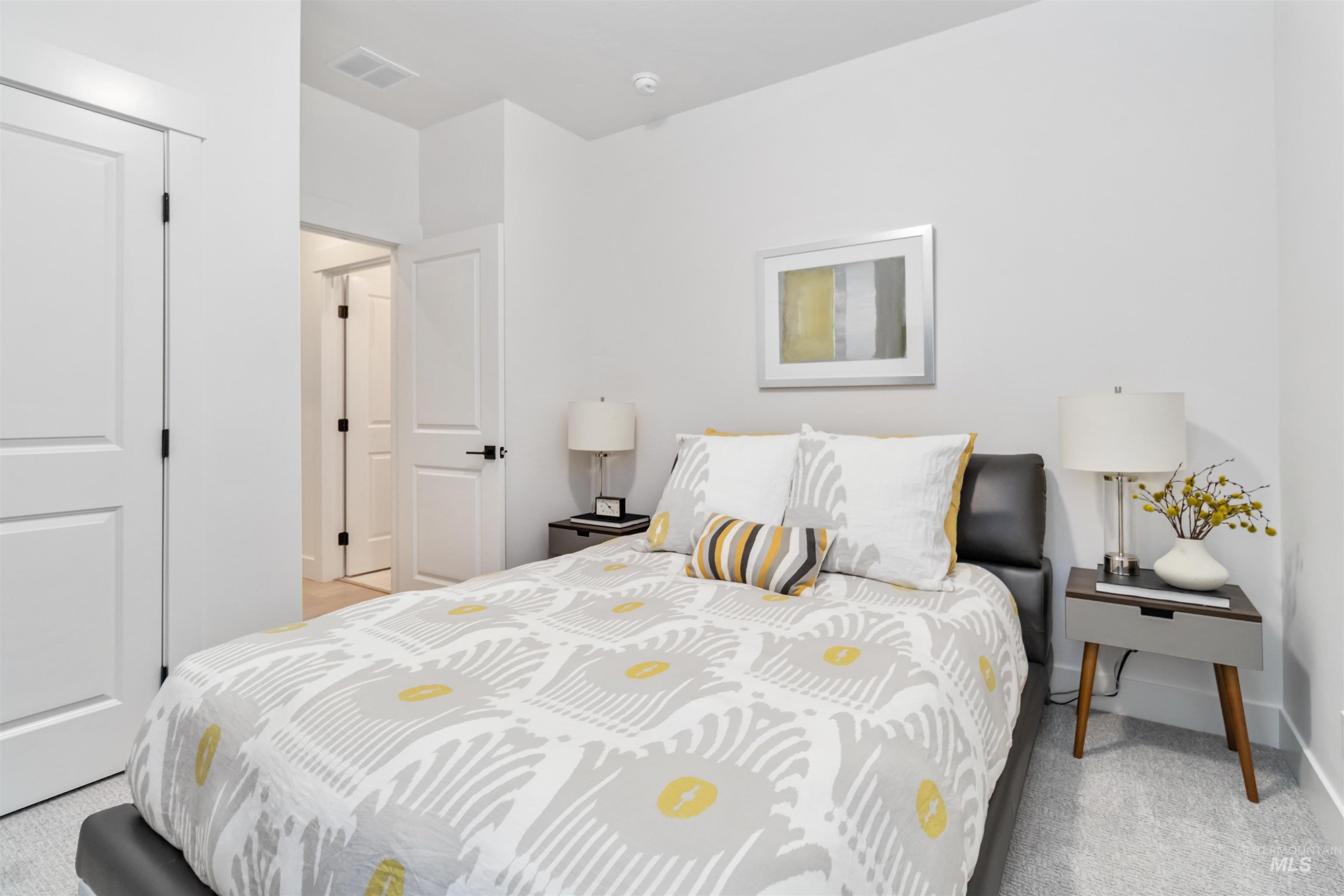 Bedroom with light colored carpet and baseboards