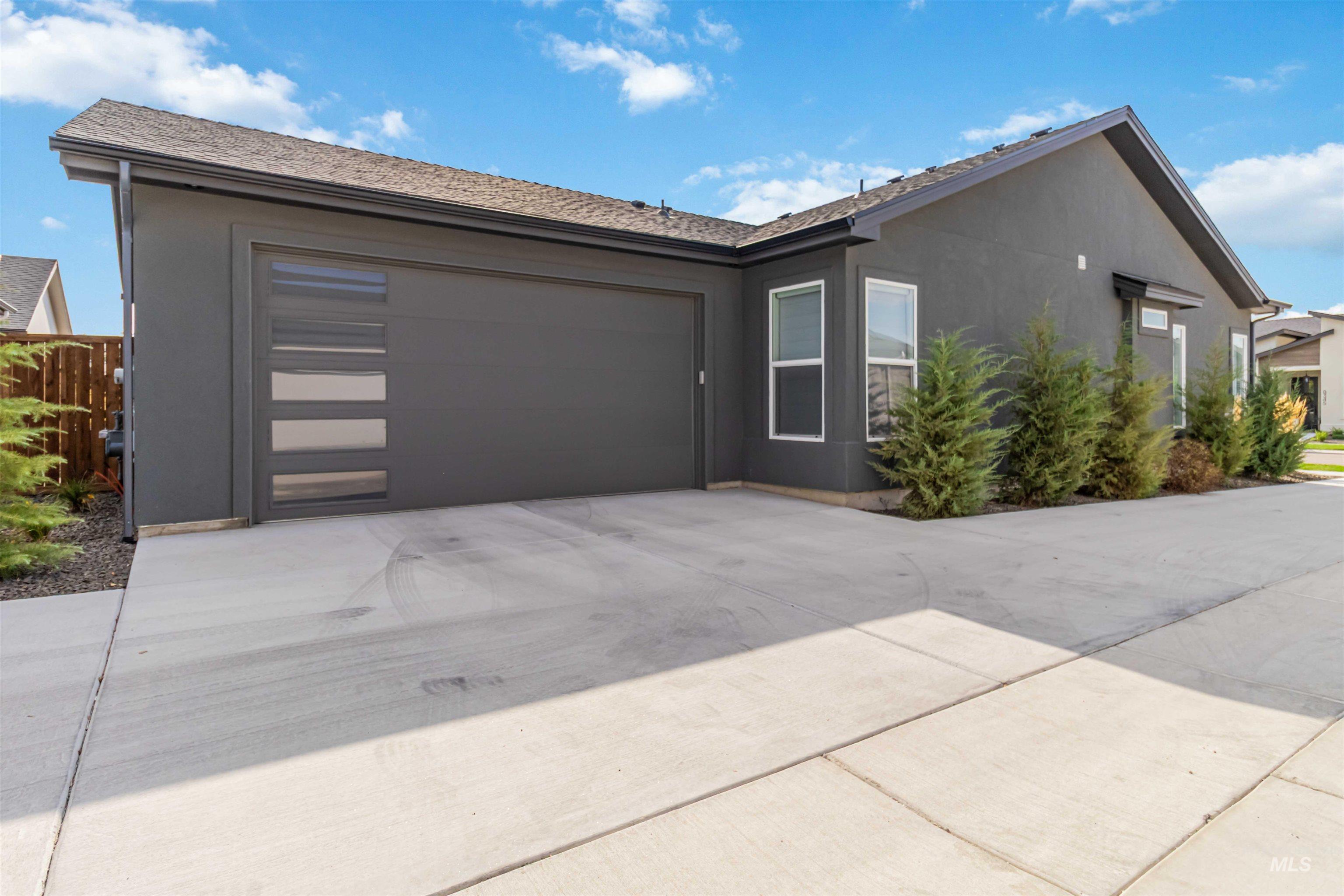 View of front of home with driveway, stucco siding, and a garage