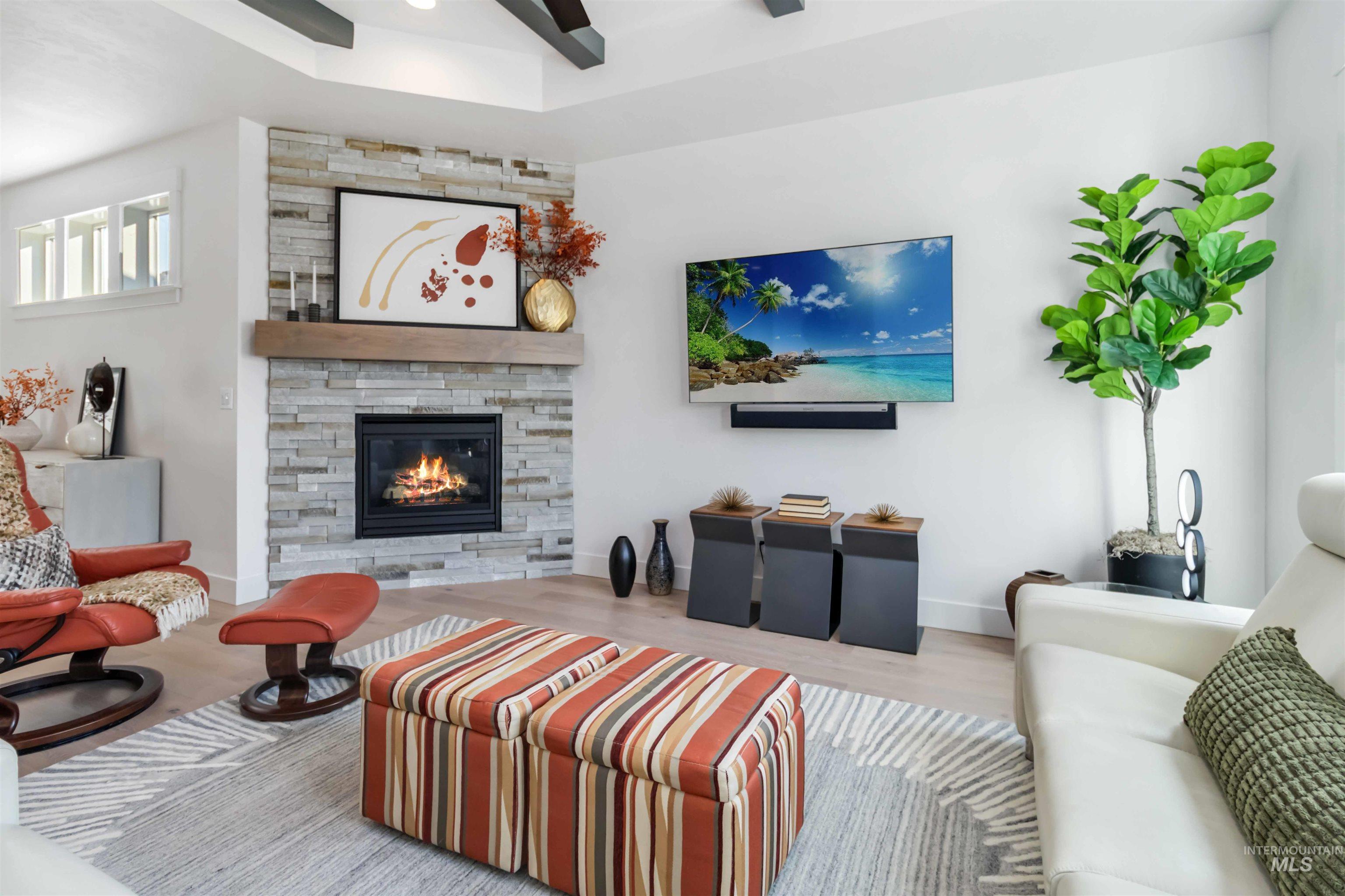 Living area featuring wood finished floors and a stone fireplace