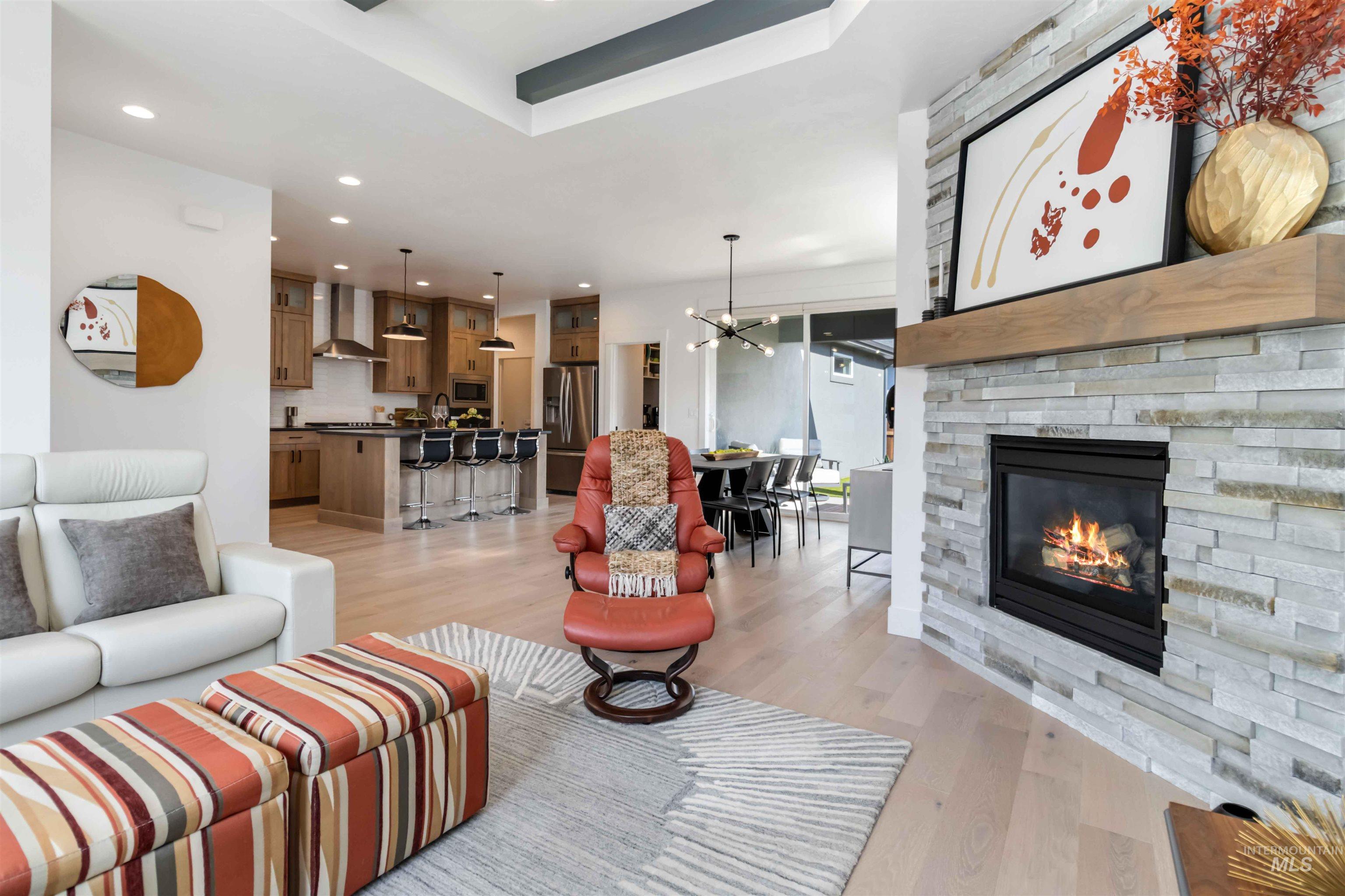 Living room featuring light wood-type flooring, recessed lighting, a chandelier, and a fireplace