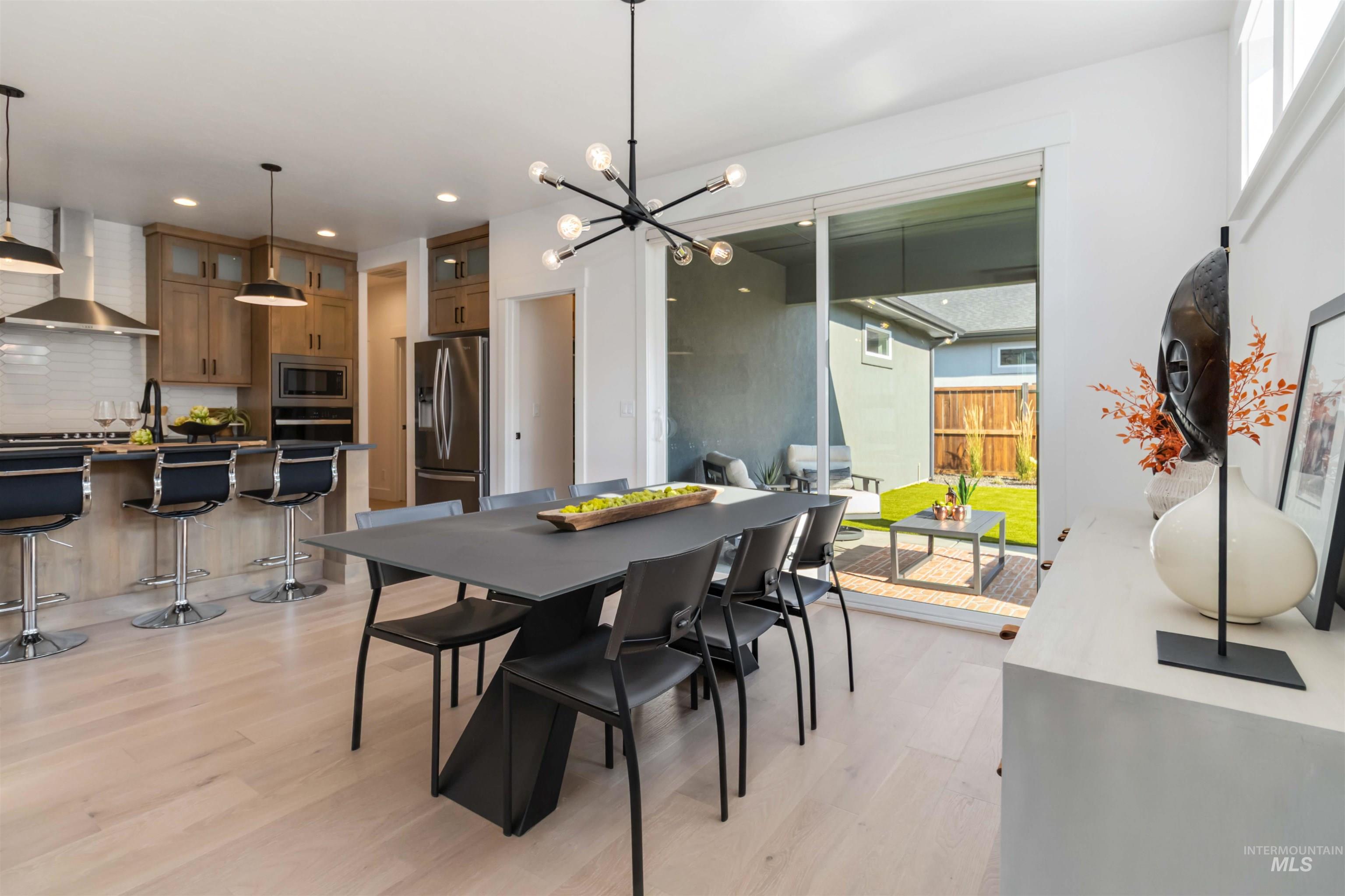Dining room with light wood-style flooring, a chandelier, and recessed lighting