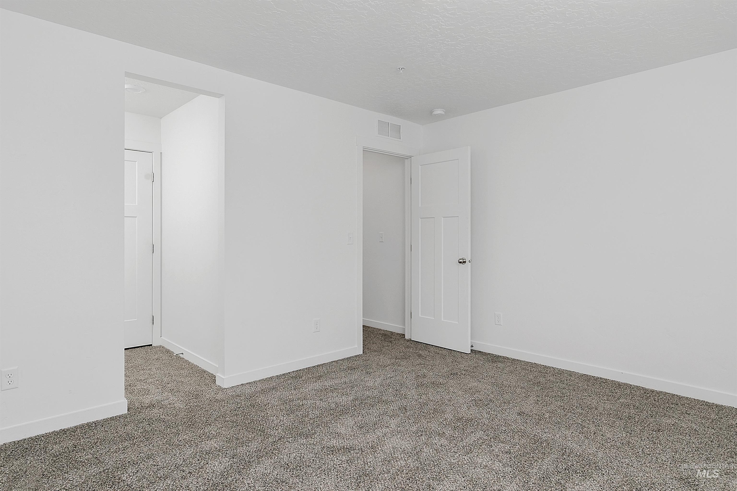 Spare room with carpet flooring and a textured ceiling