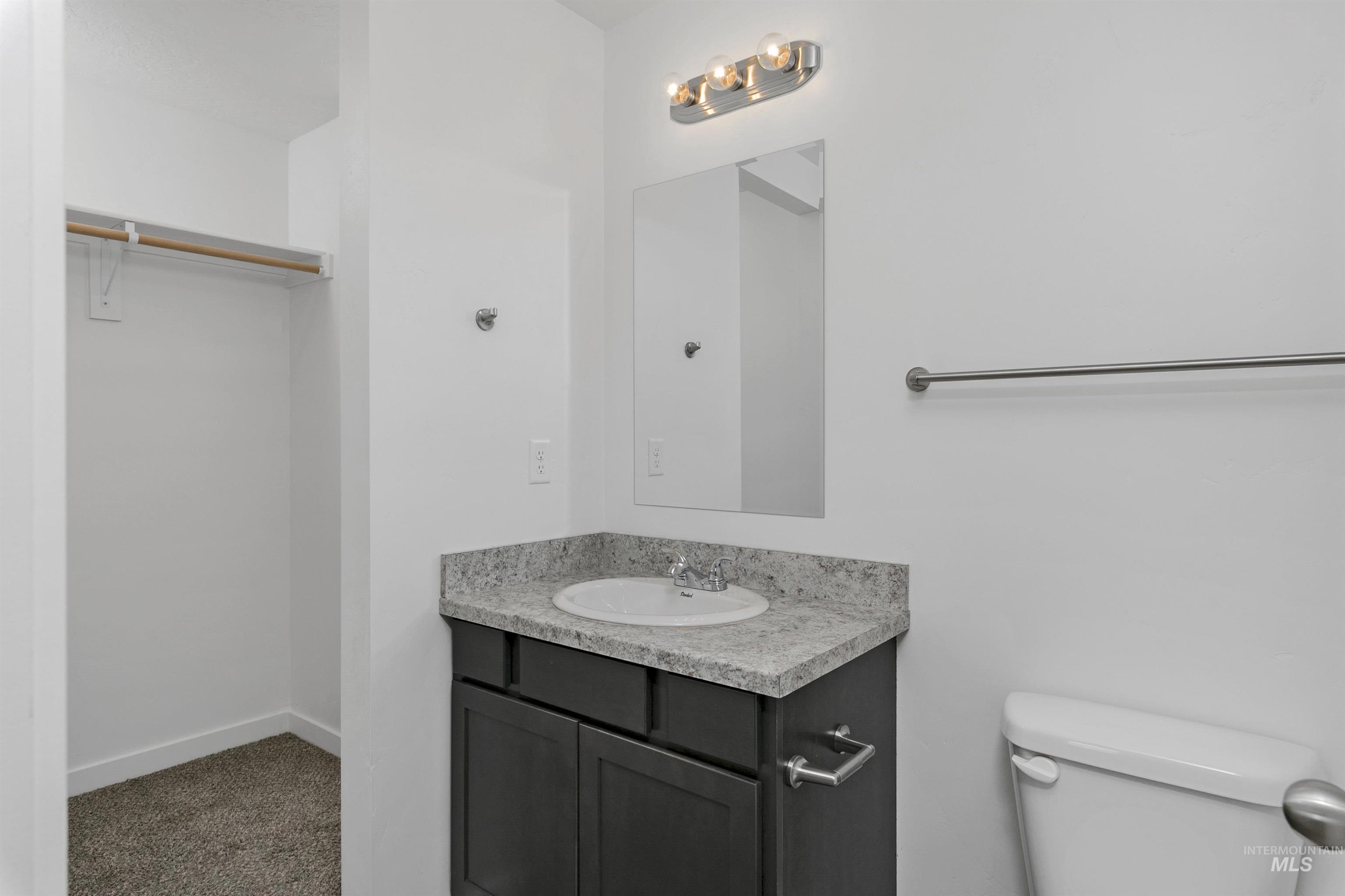 Bathroom with vanity and a spacious closet