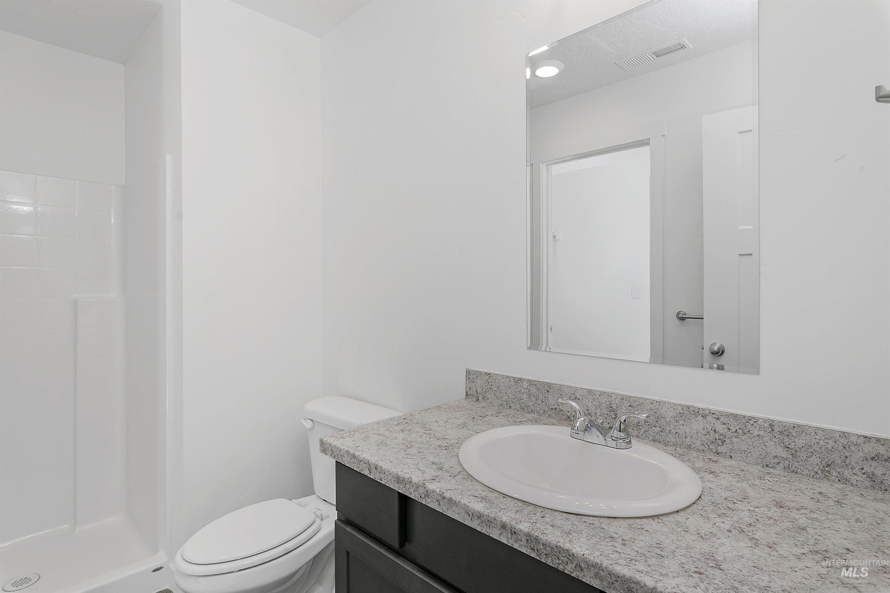 Full bathroom with vanity and a shower stall