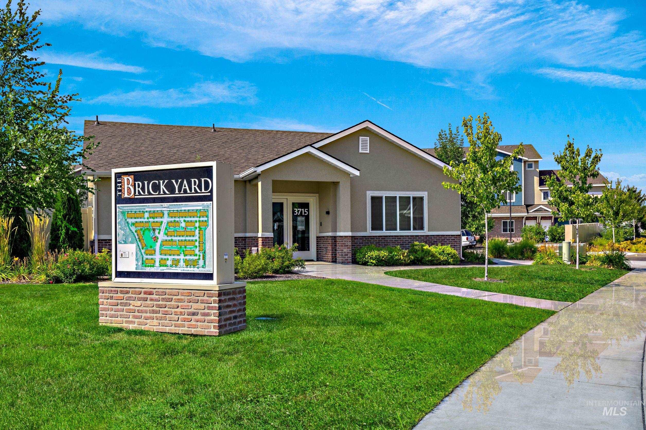 View of front of home with brick siding, a front lawn, stucco siding, and roof with shingles