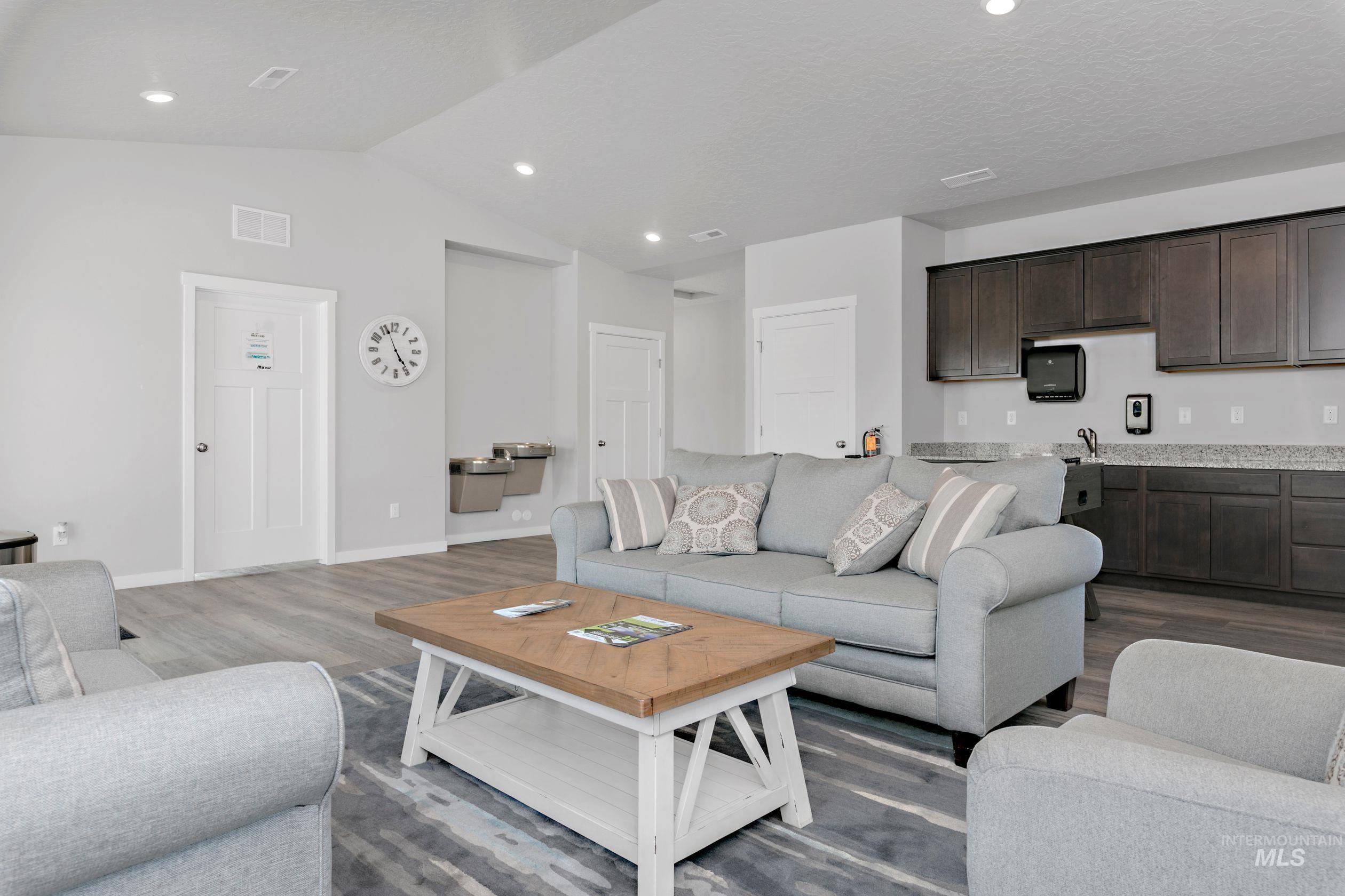 Living area featuring wood finished floors, vaulted ceiling, and recessed lighting