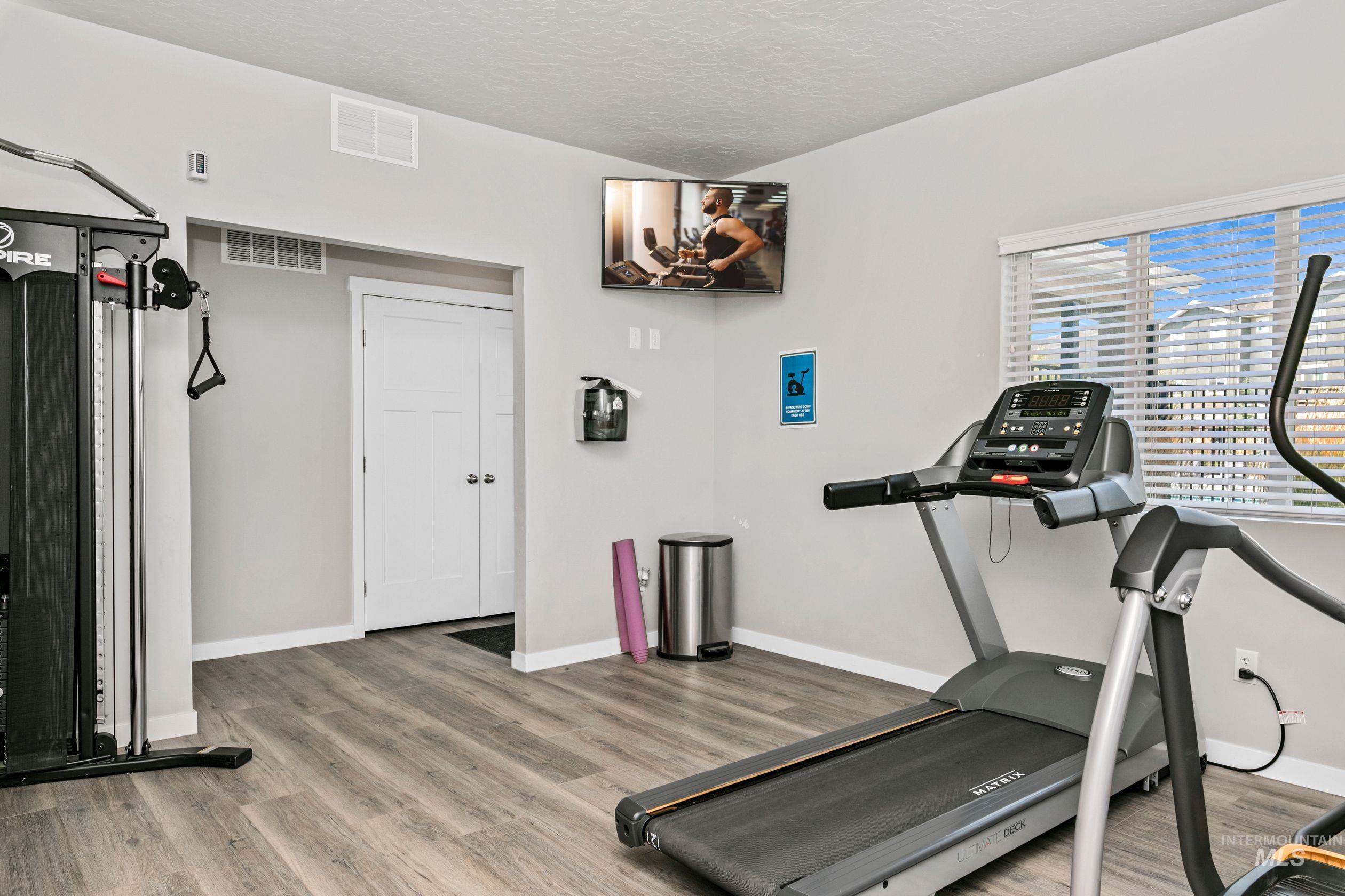 Workout room featuring light wood-style flooring and a textured ceiling