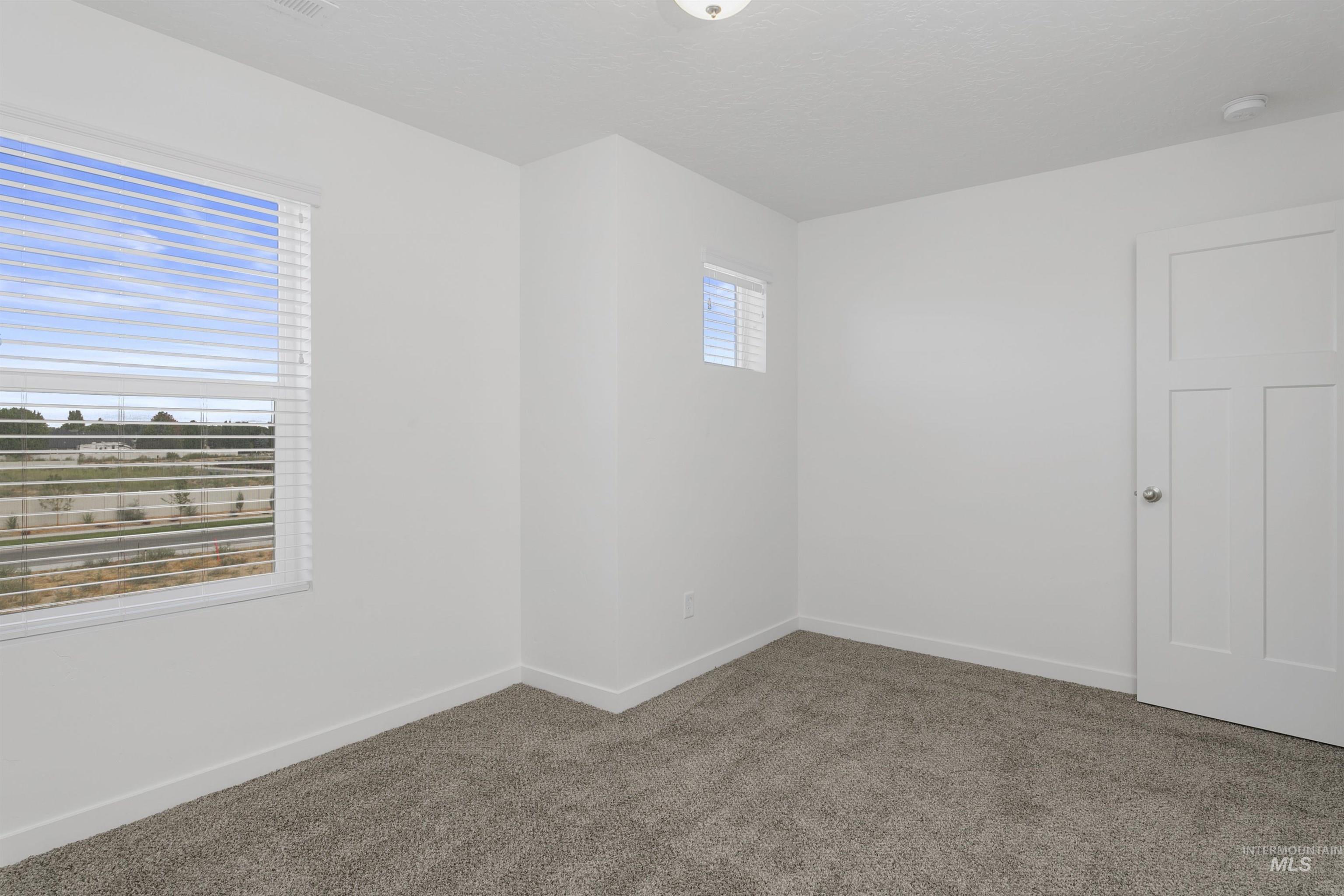 Carpeted empty room featuring baseboards