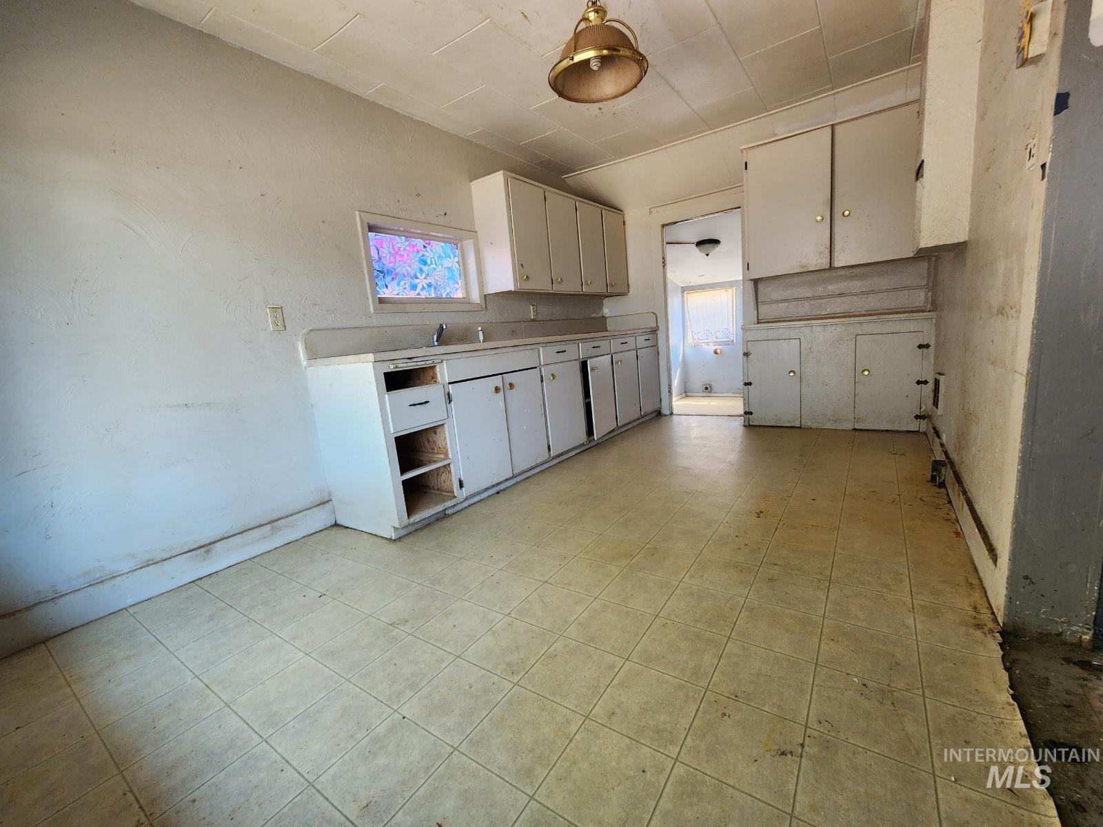 Kitchen with light countertops, healthy amount of natural light, open shelves, and white cabinetry