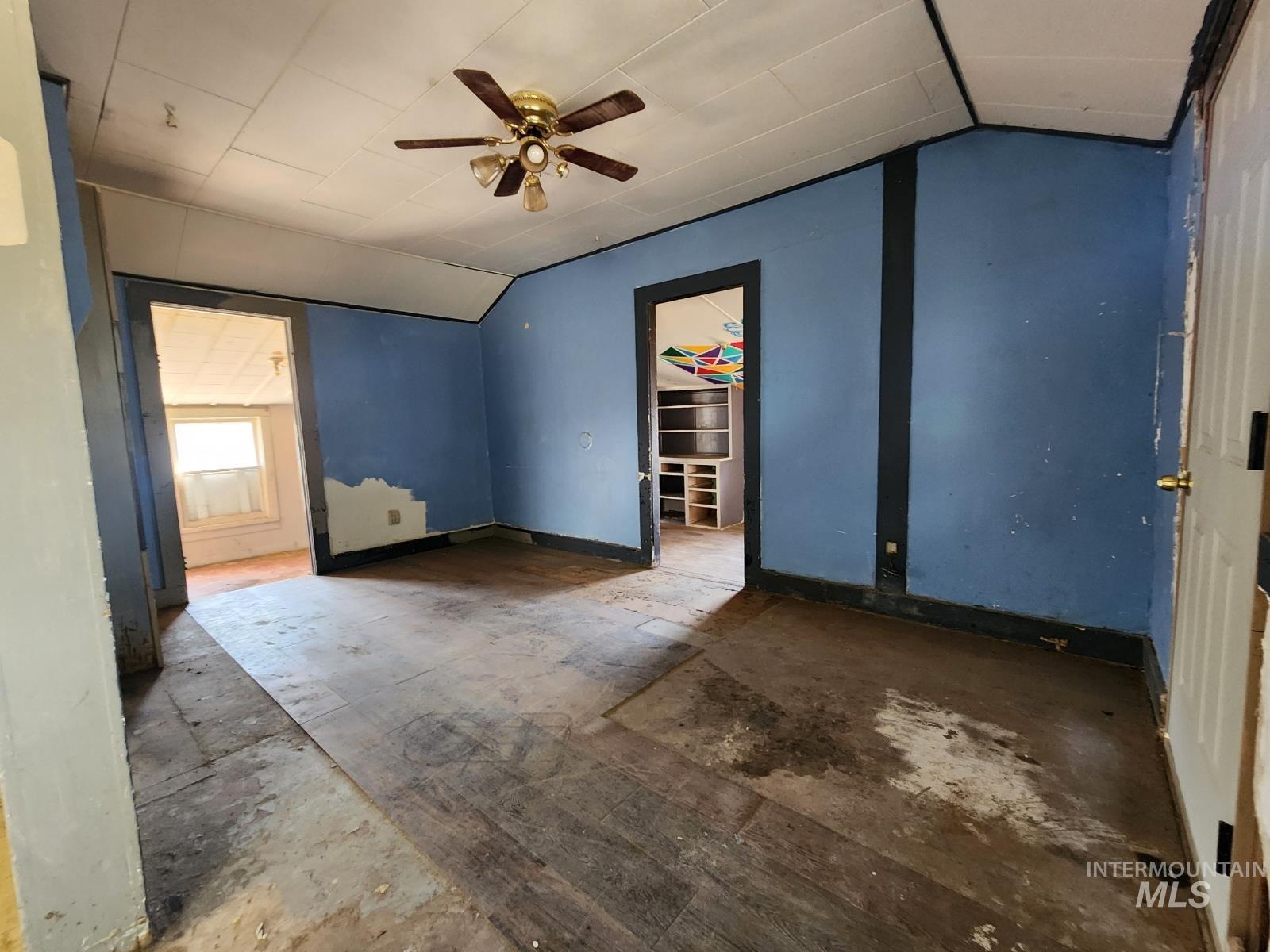 Unfurnished bedroom featuring lofted ceiling and a ceiling fan