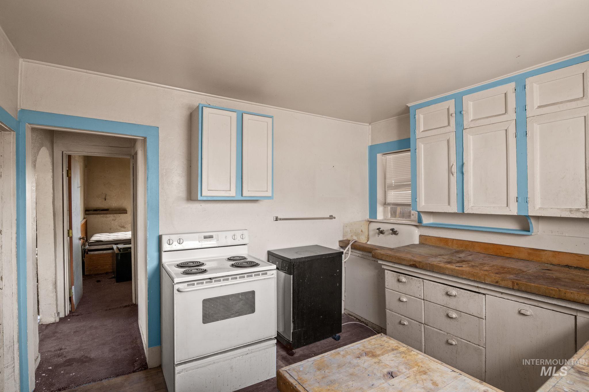 Kitchen featuring electric stove and white cabinets