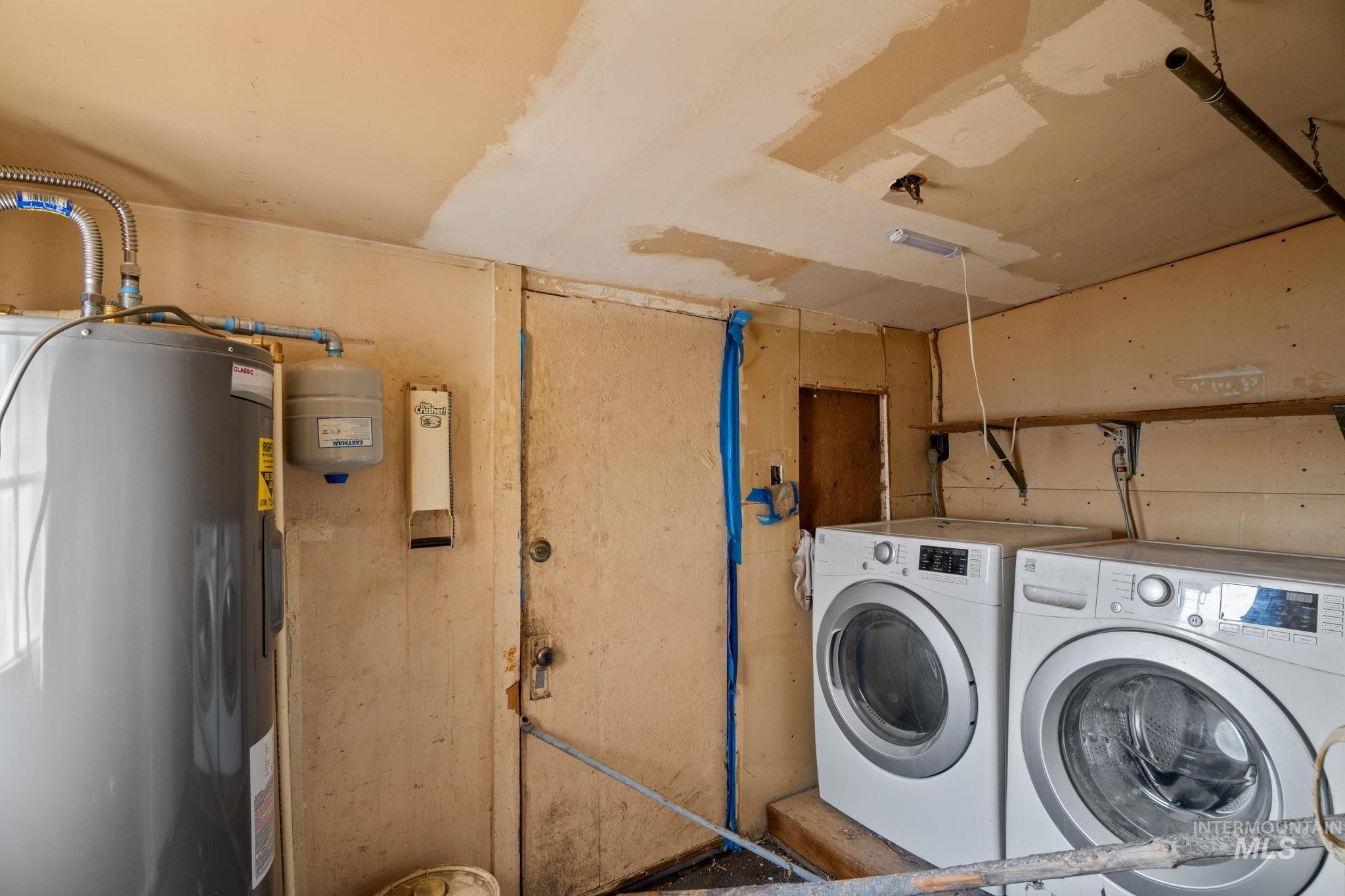 Laundry area featuring electric water heater and independent washer and dryer