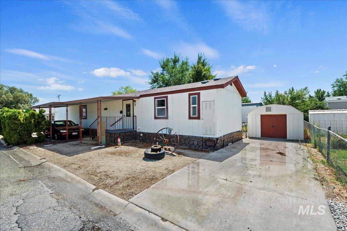 Manufactured / mobile home with a storage shed and covered porch